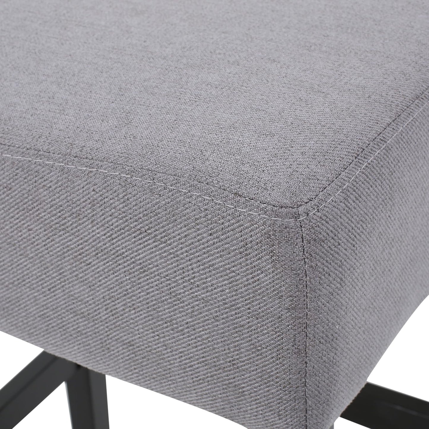 Closeup of grey fabric upholstery on a stool seat with visible stitching