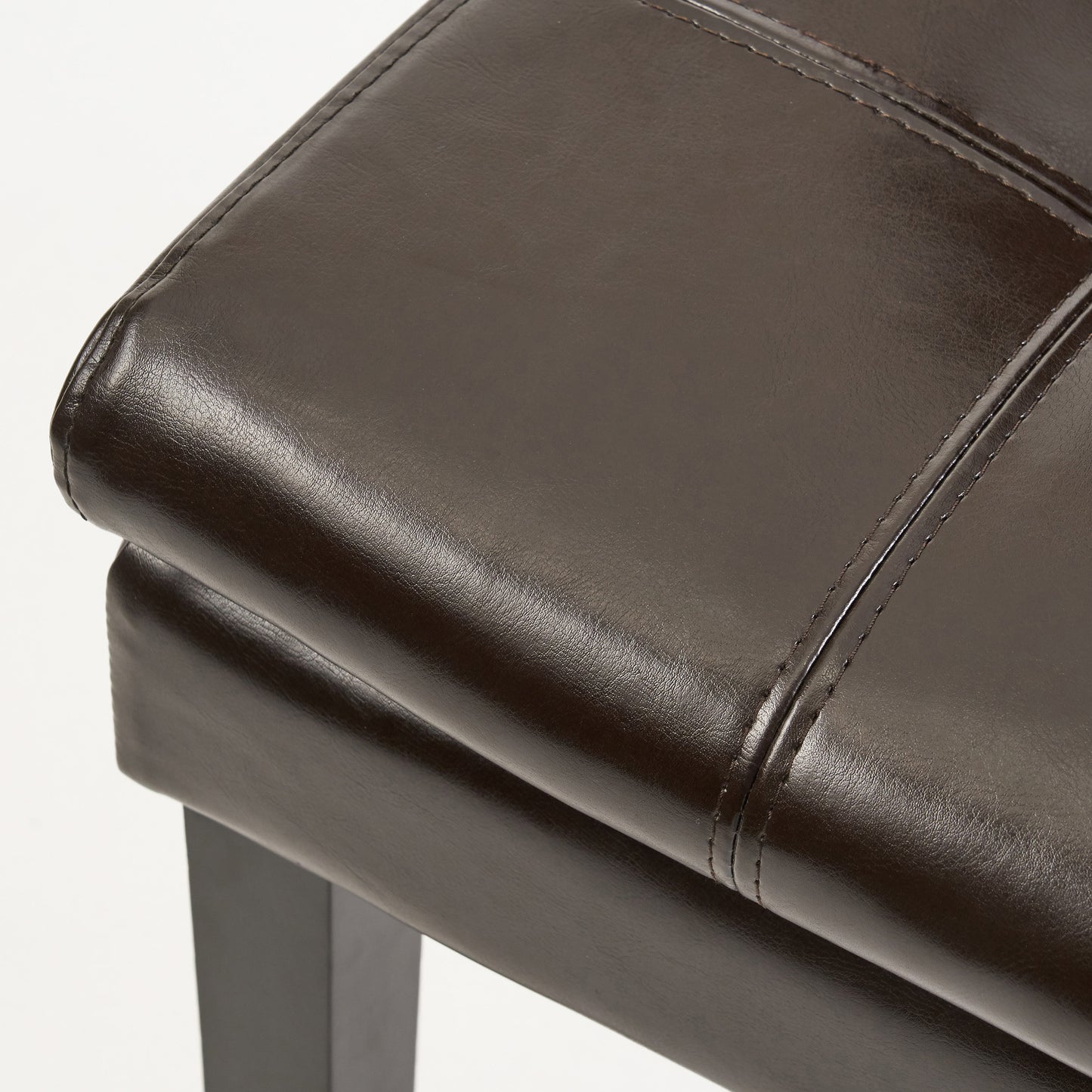 Dark brown faux leather ottoman with stitched panel detail and sturdy dark legs