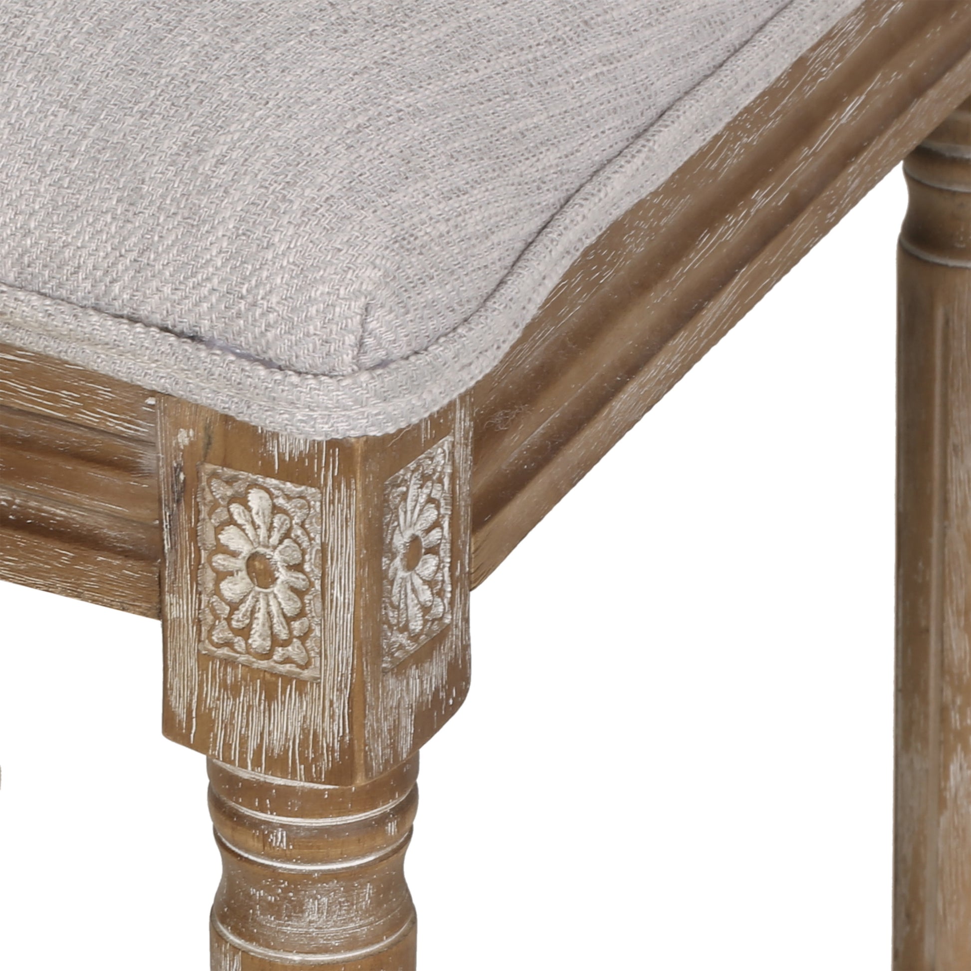 Light gray woven fabric seat on a distressed wood accent chair with carved details
