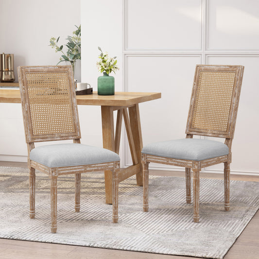 Two rustic distressed wood dining chairs with cane backs and grey upholstered seats