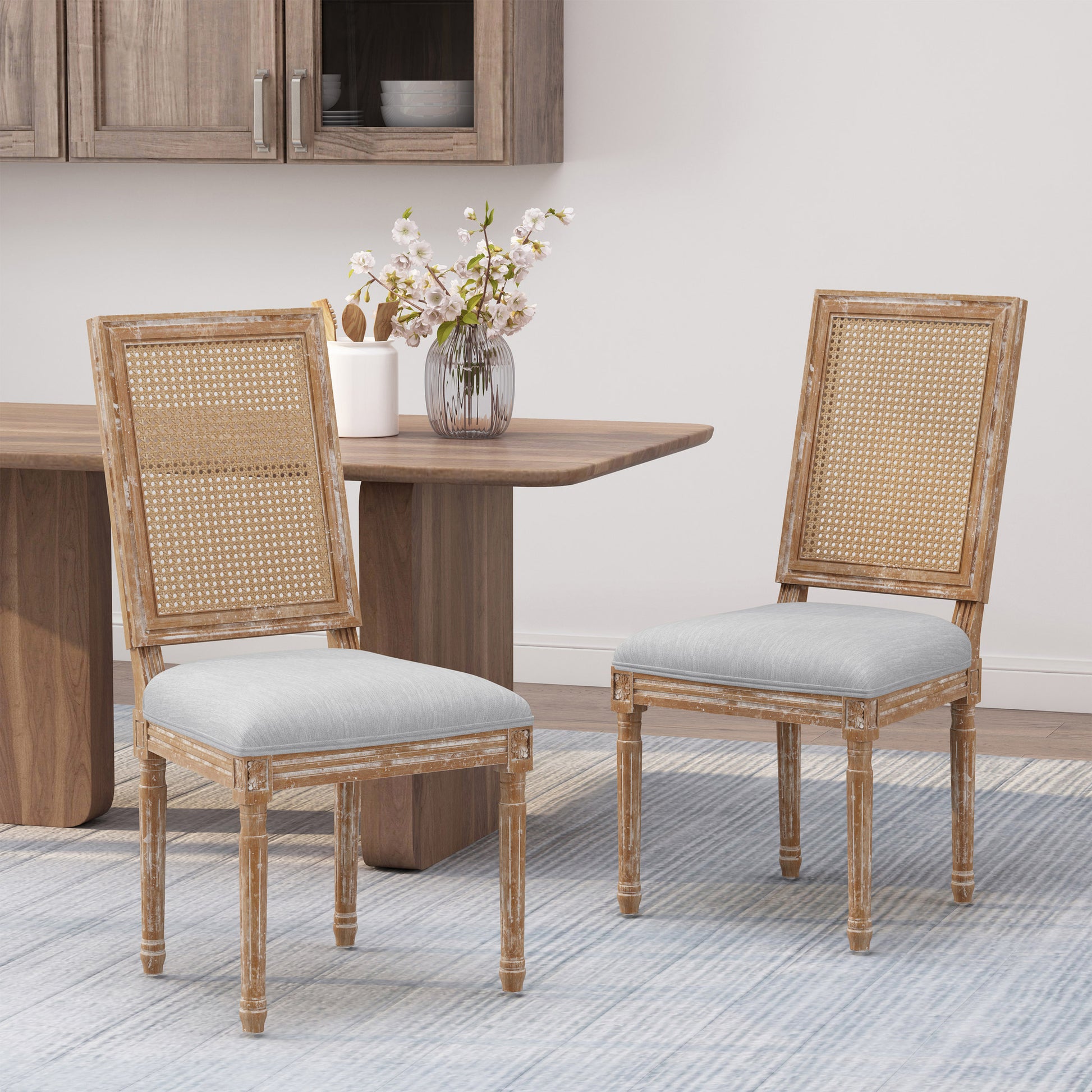 French country cane back dining chair with light grey upholstered seat and distressed wood frame