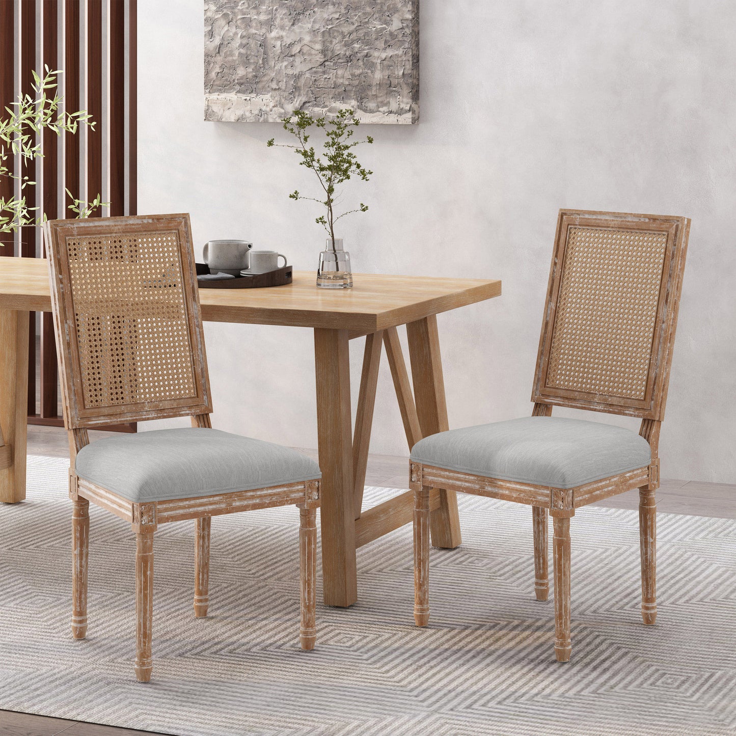 Two distressed wood cane back dining chairs with light grey upholstered seats