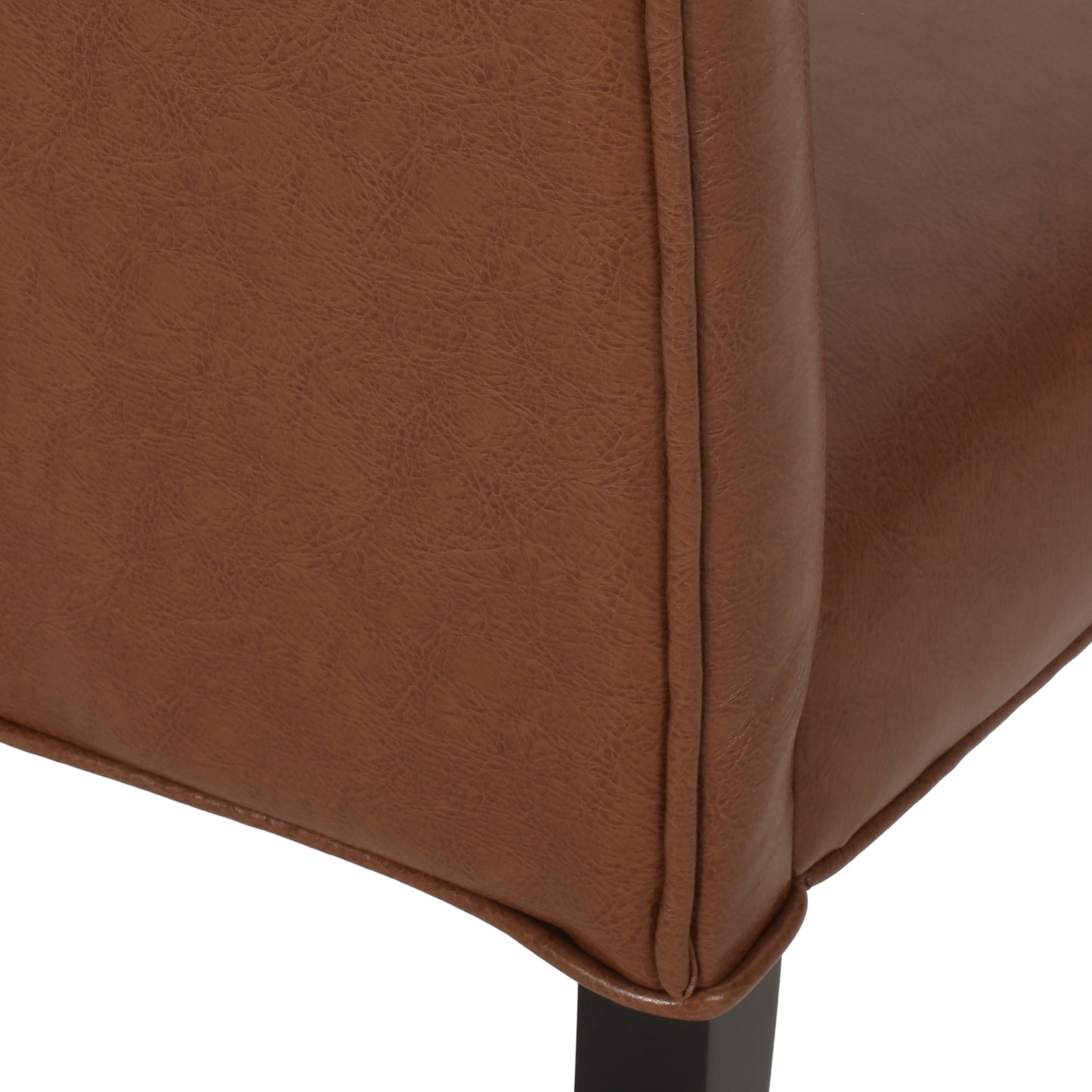 Closeup of a brown faux leather armchair side with detailed stitching and a white background