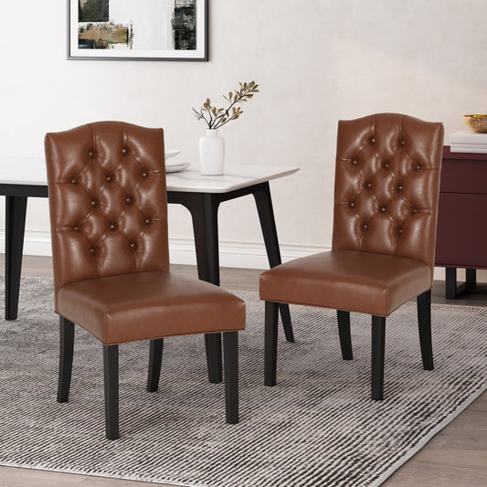 Two brown faux leather tufted dining chairs with dark wood legs