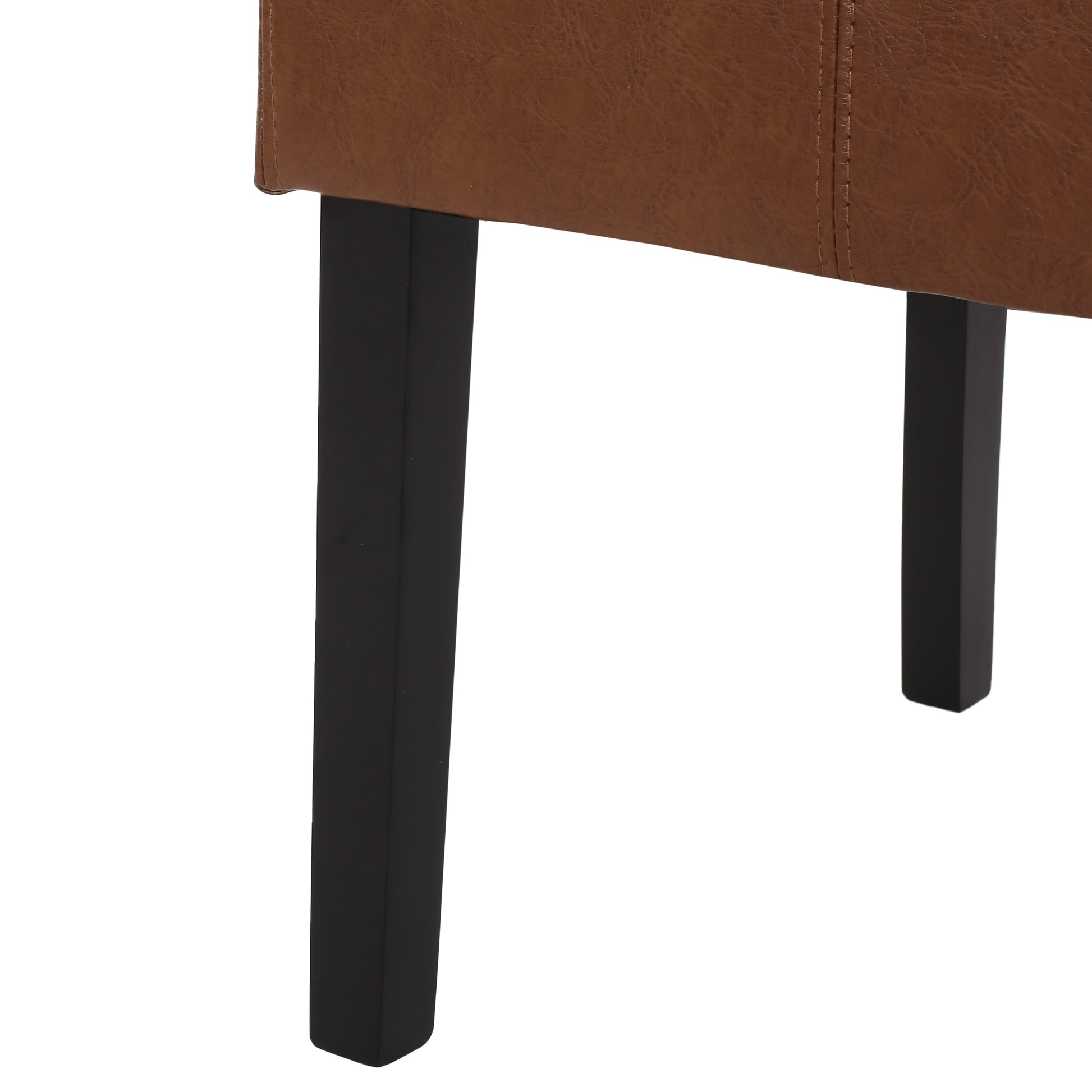 Closeup of brown vegan leather tufted armchair with sleek black legs