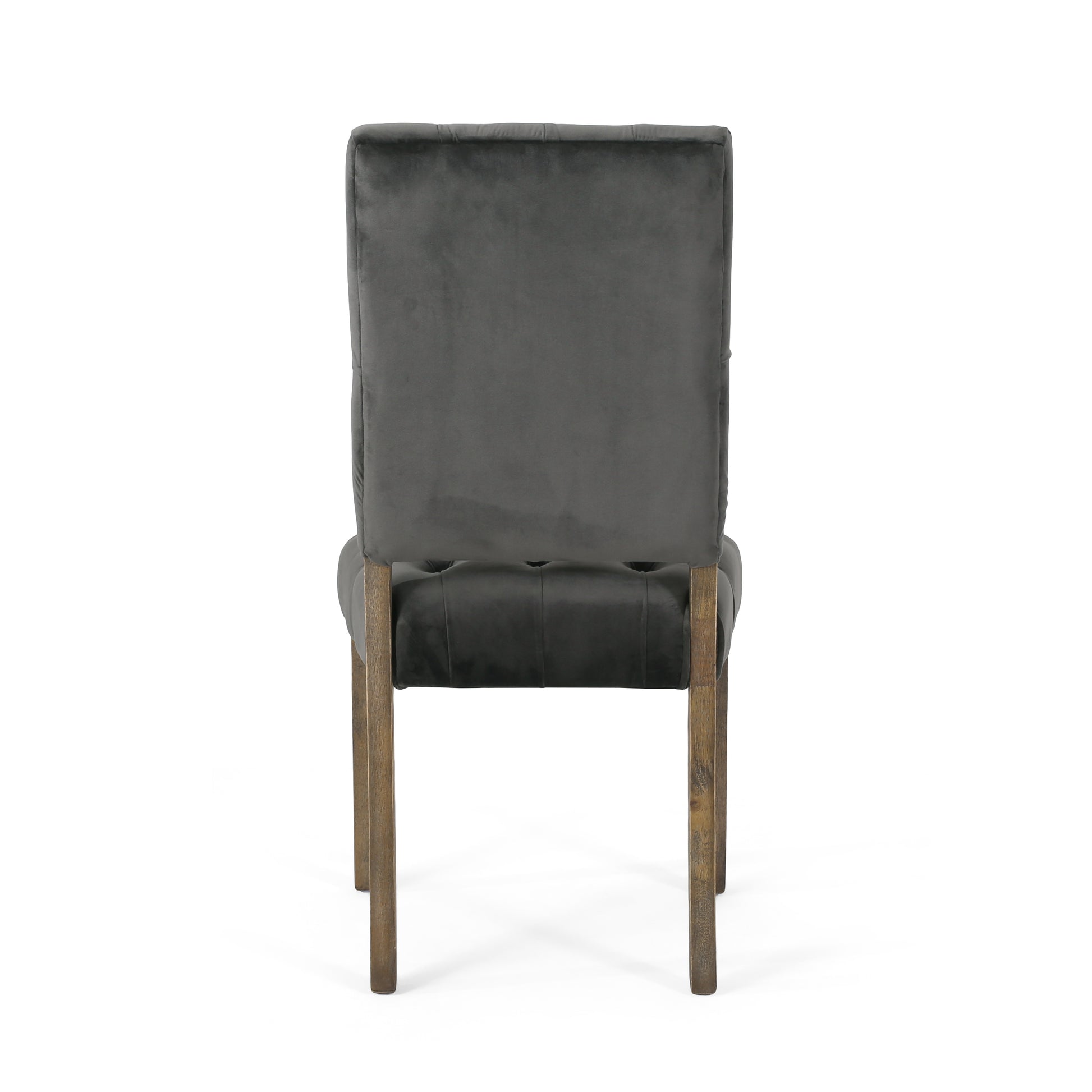 Tufted dark gray velvet dining chair with carved wooden legs and button tufting detail