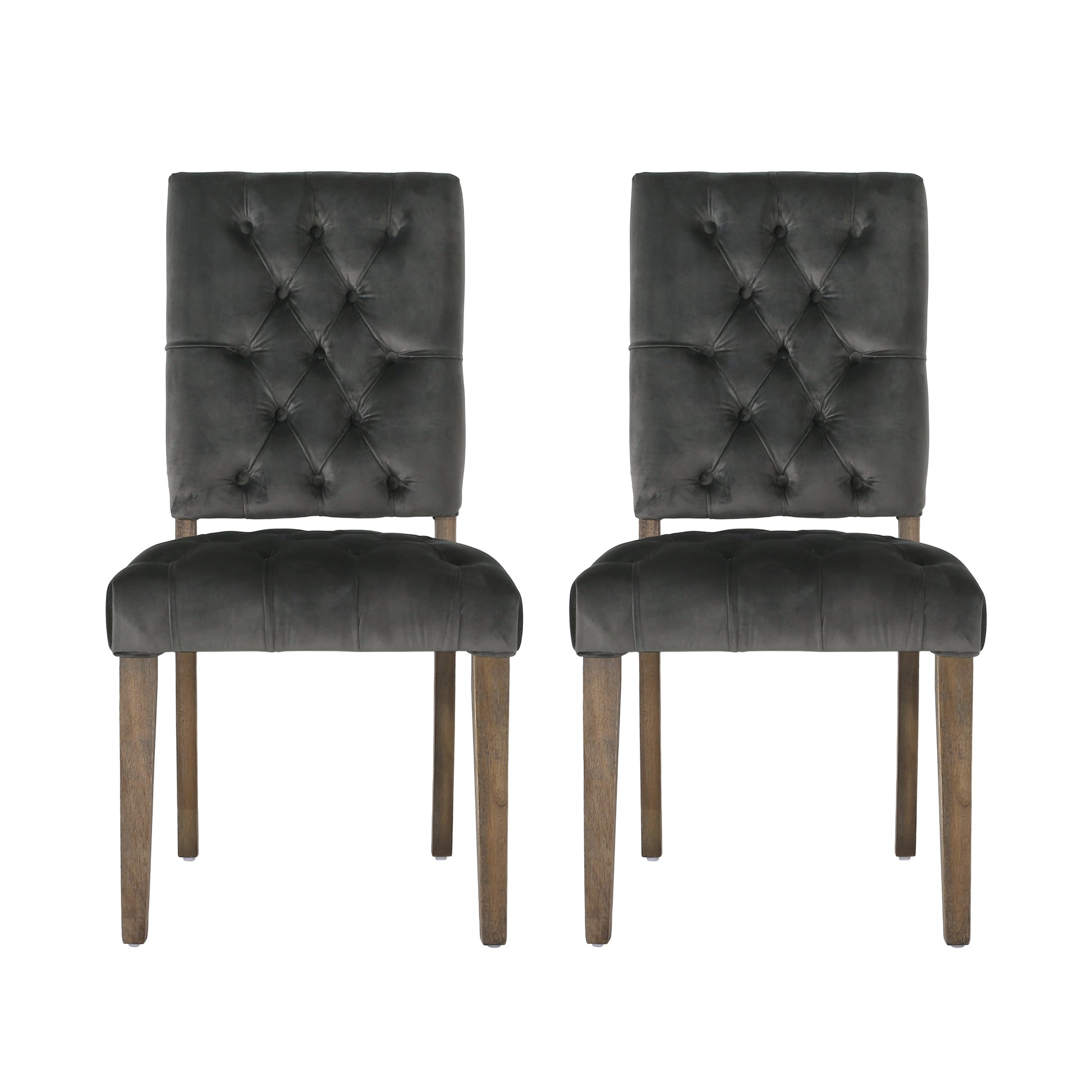 Two dark grey velvet dining chairs with tufted backs and wooden legs