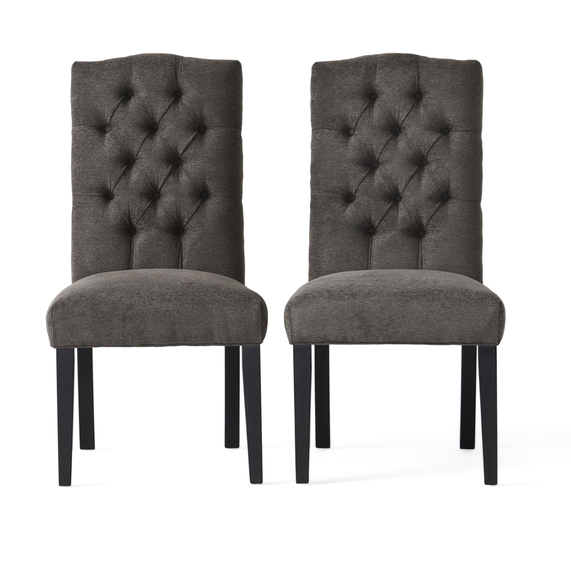 Two dark grey upholstered dining chairs with tufted backs and black legs