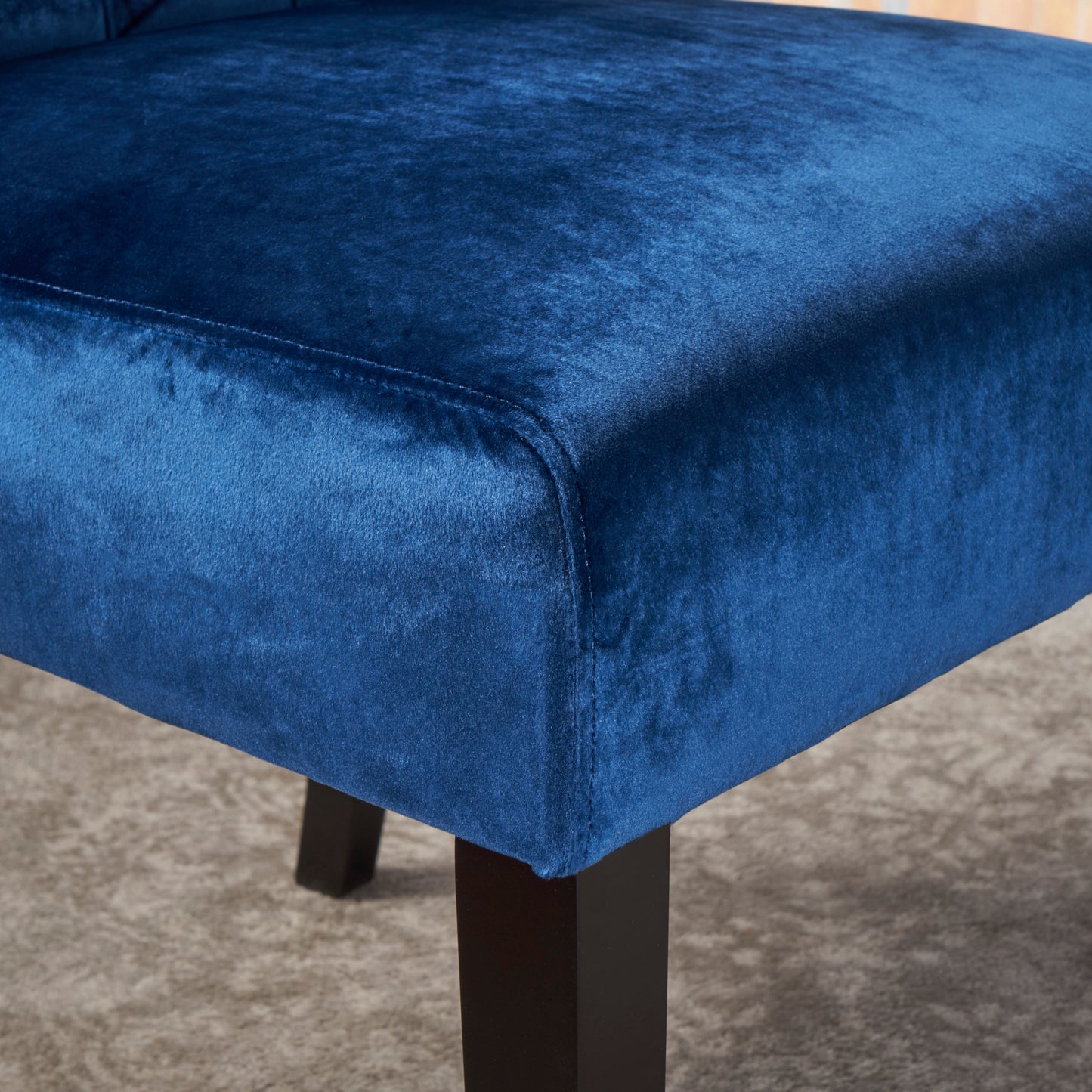 Closeup of luxurious royal blue velvet upholstery on a plush accent chair