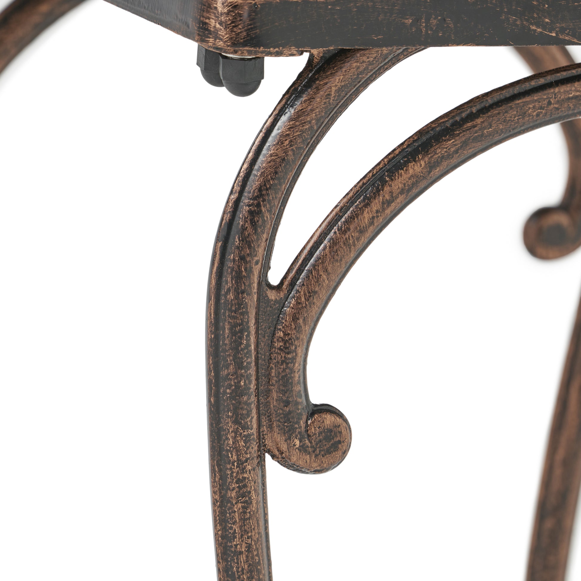 Detail of antique bronze metal scrollwork on a furniture leg