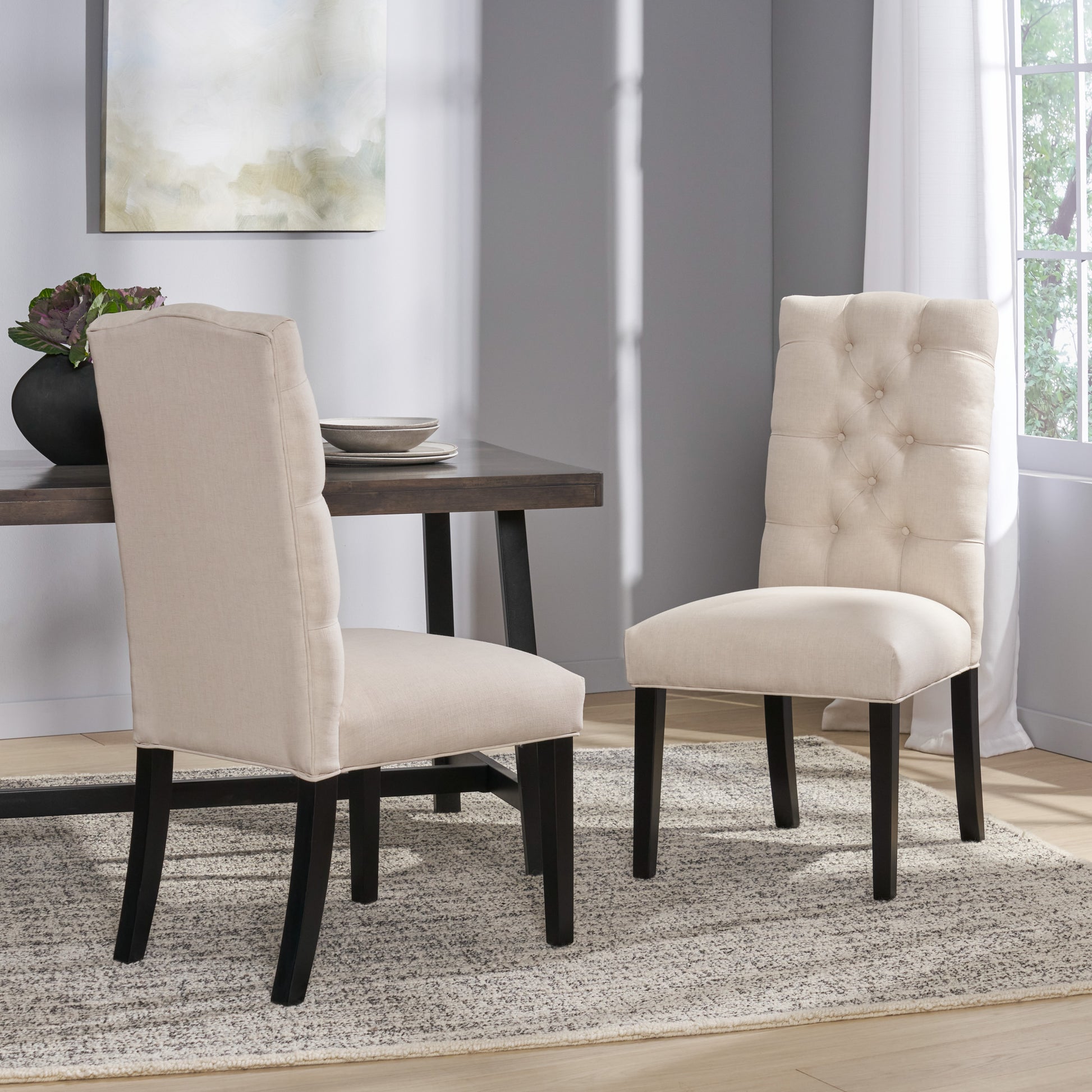 Tufted beige upholstered dining chair with dark wood legs elegant button detail on the back