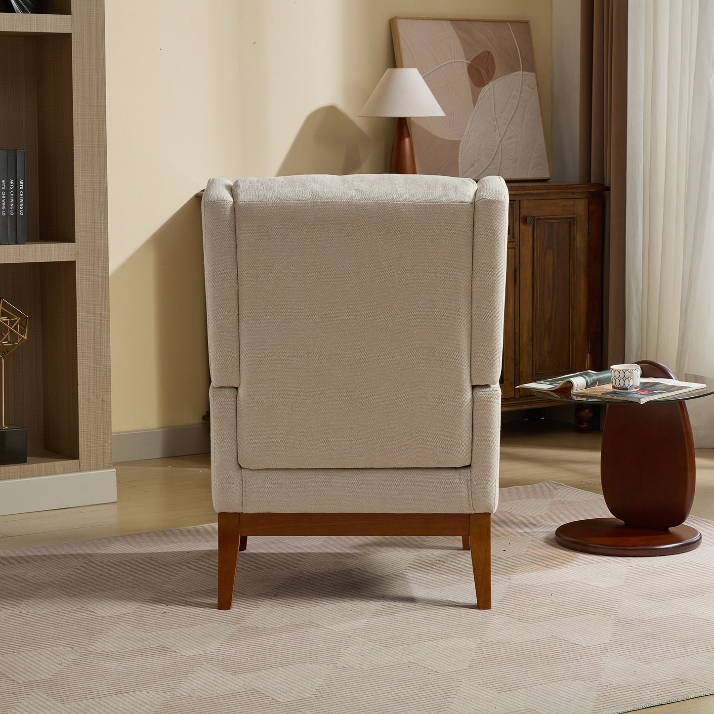 Back view of a neutraltoned upholstered wingback chair with dark wood legs