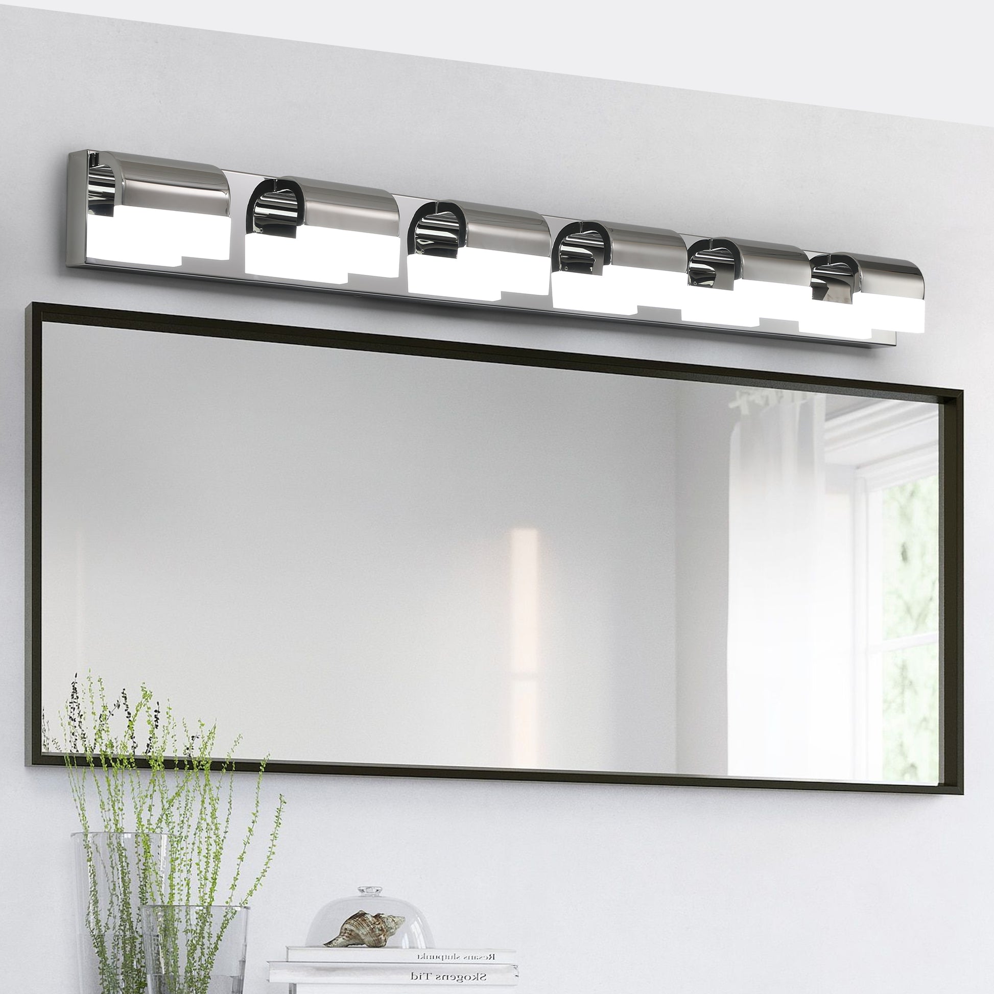 Chrome light vanity fixture with frosted glass shades and a rectangular black mirror