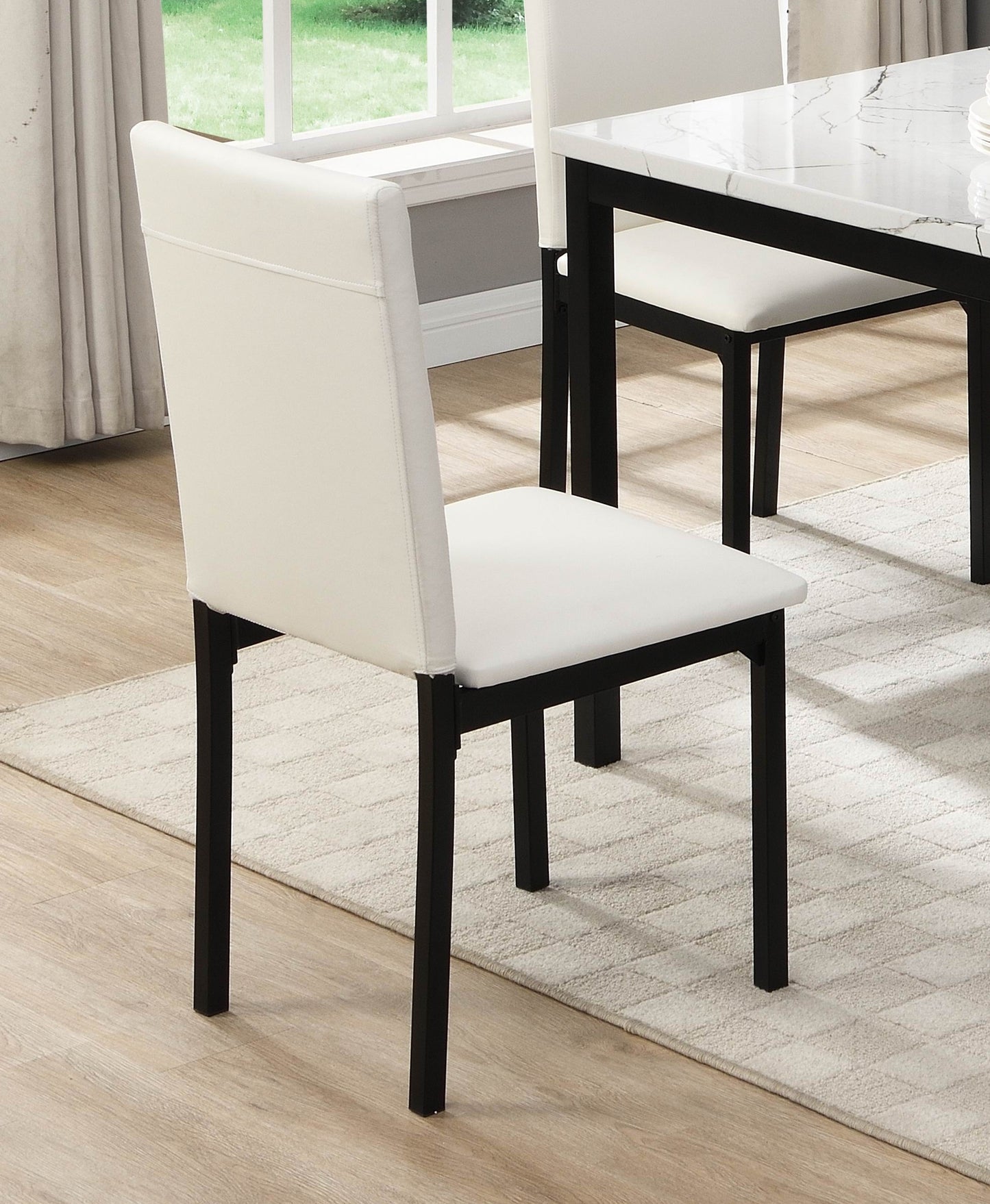 Modern cream faux leather dining chair with black metal legs on a rug