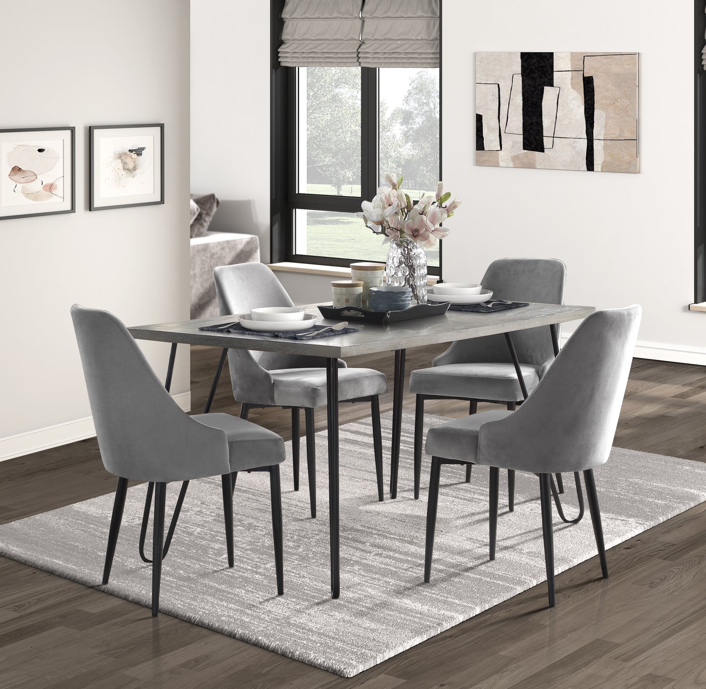 Modern gray velvet dining chairs arranged around a distressed wood table