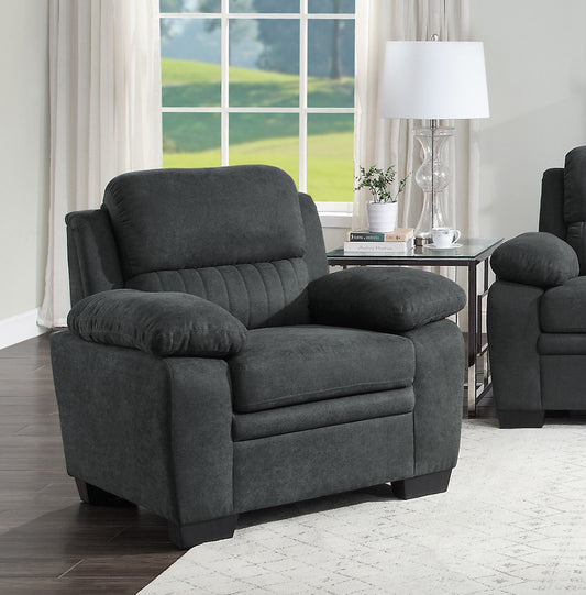 Charcoal gray recliner chair with plush cushions and channel tufting on the backrest