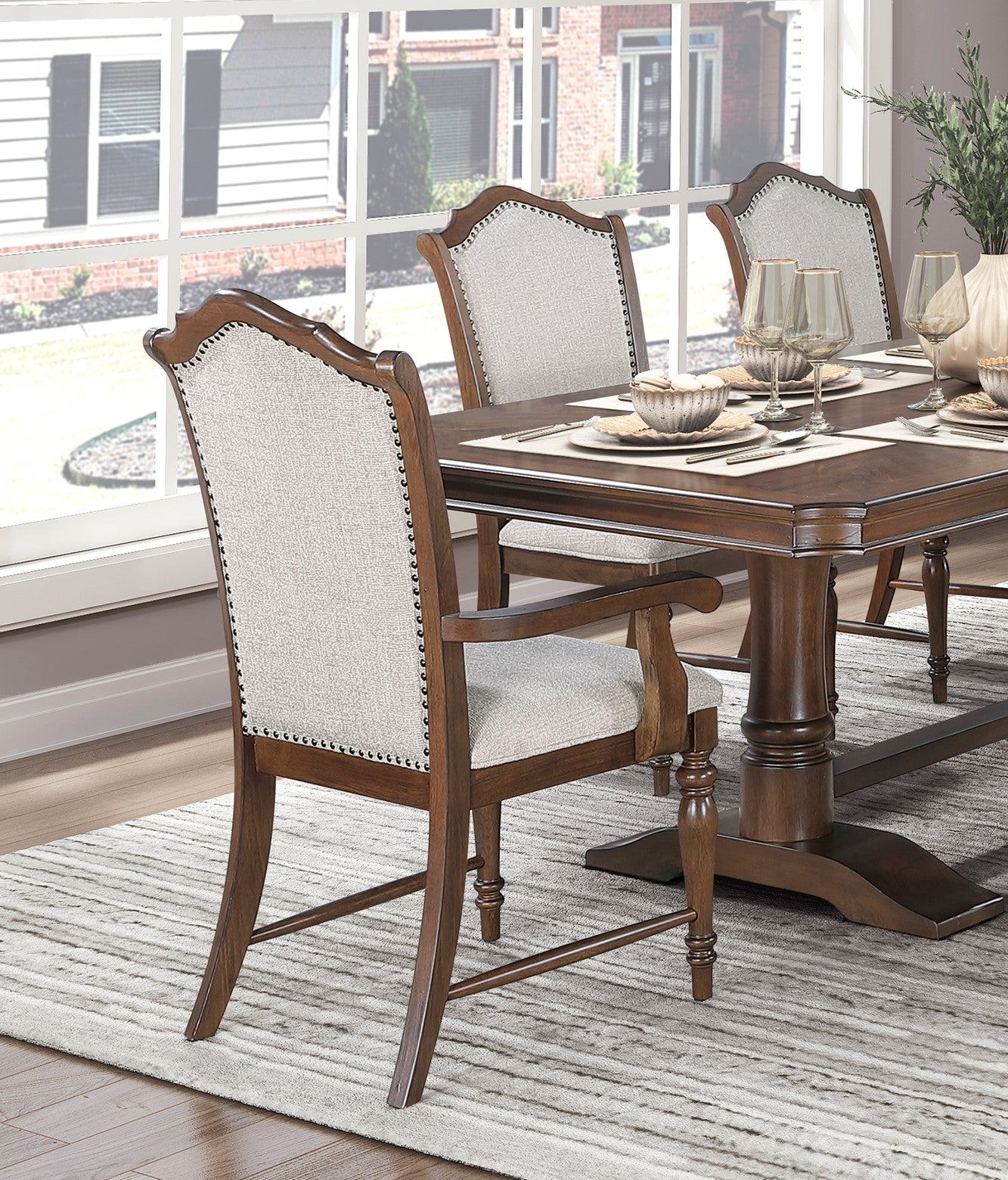 Ornate wooden dining chair with light grey upholstered seat and back nailhead trim