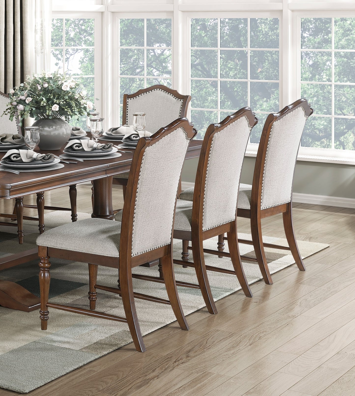Tufted upholstered dining chair with nailhead trim in a light beige fabric and a dark wood frame