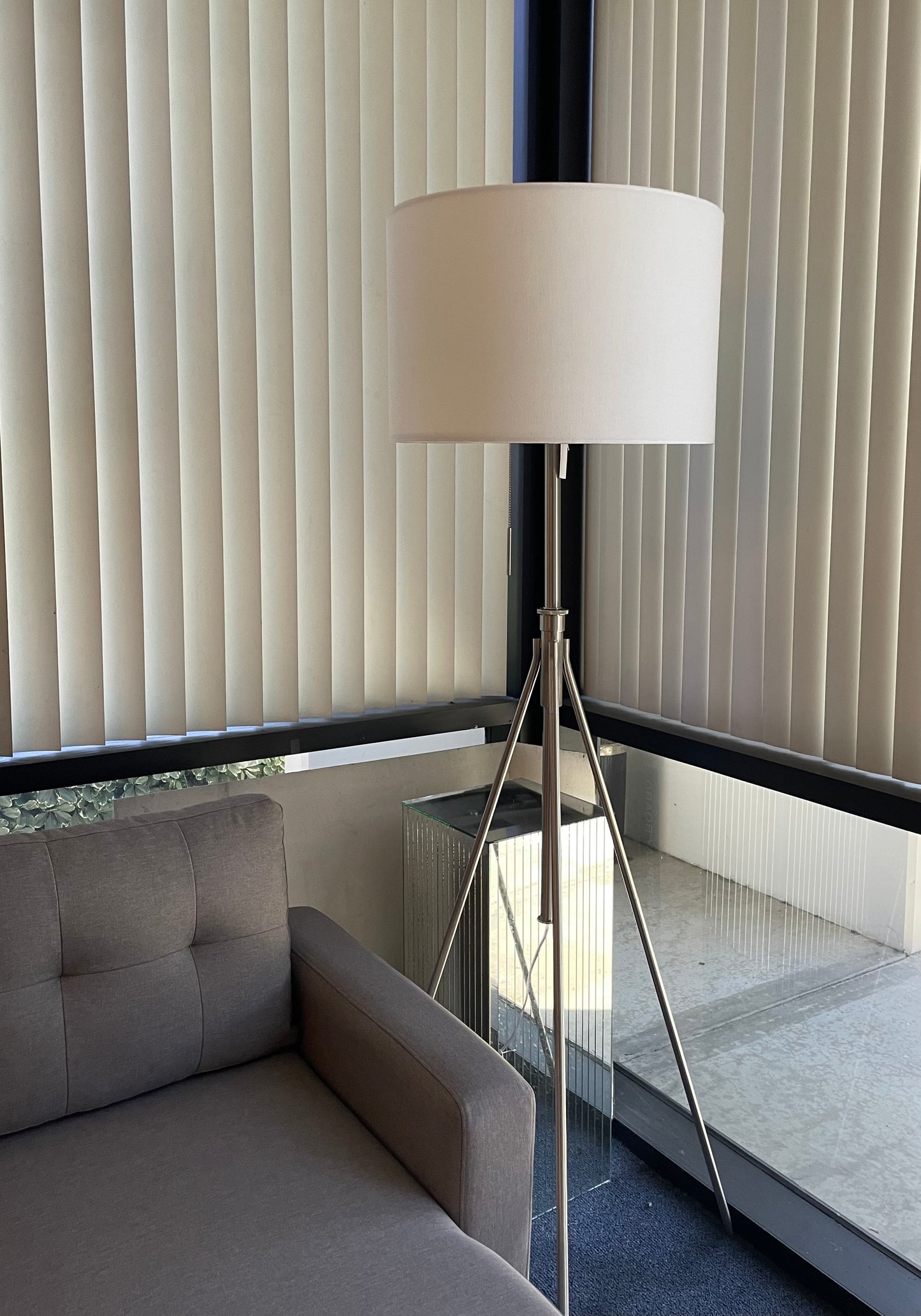 Sleek silver tripod floor lamp with a white drum shade modern accent for any living room