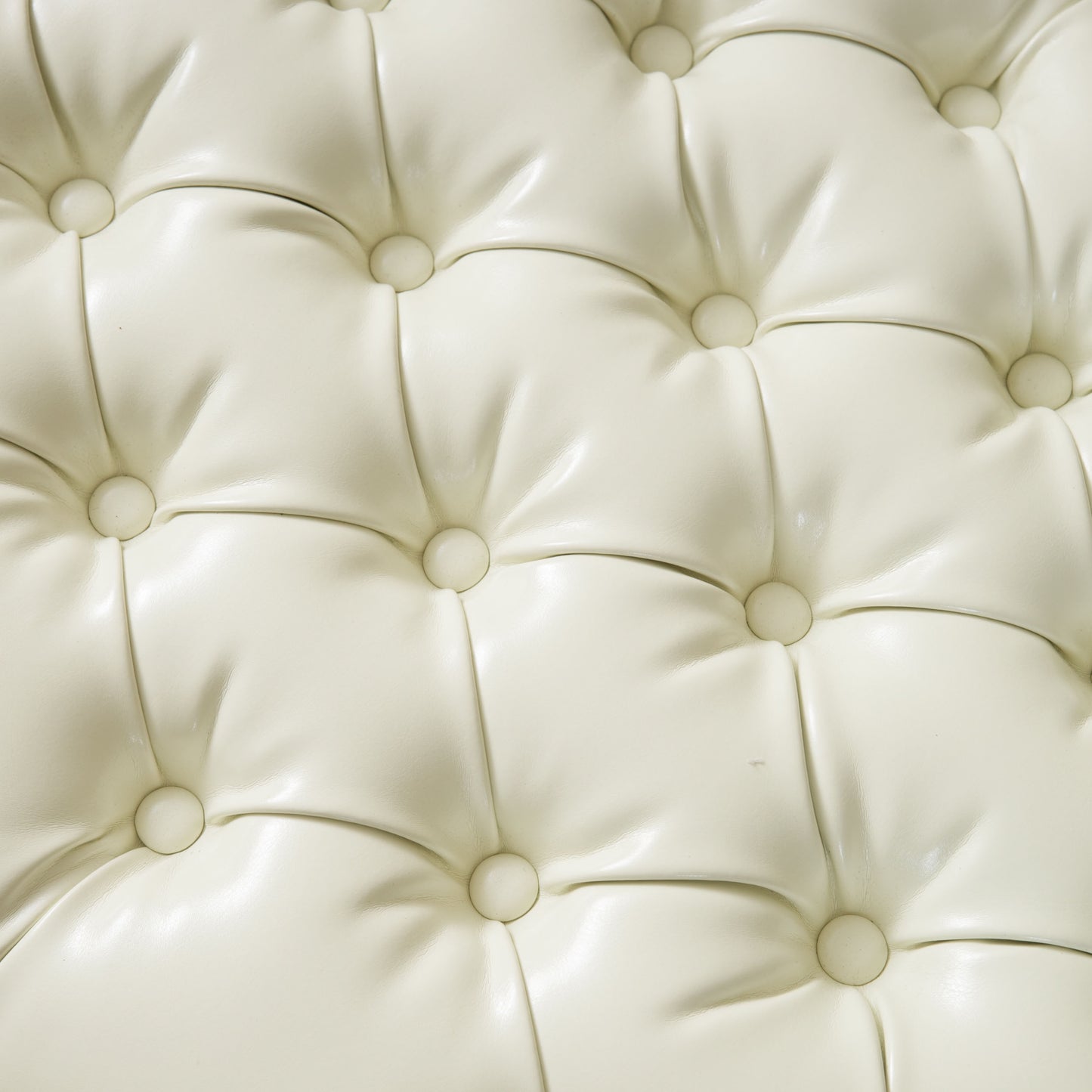 Cream tufted faux leather ottoman detail