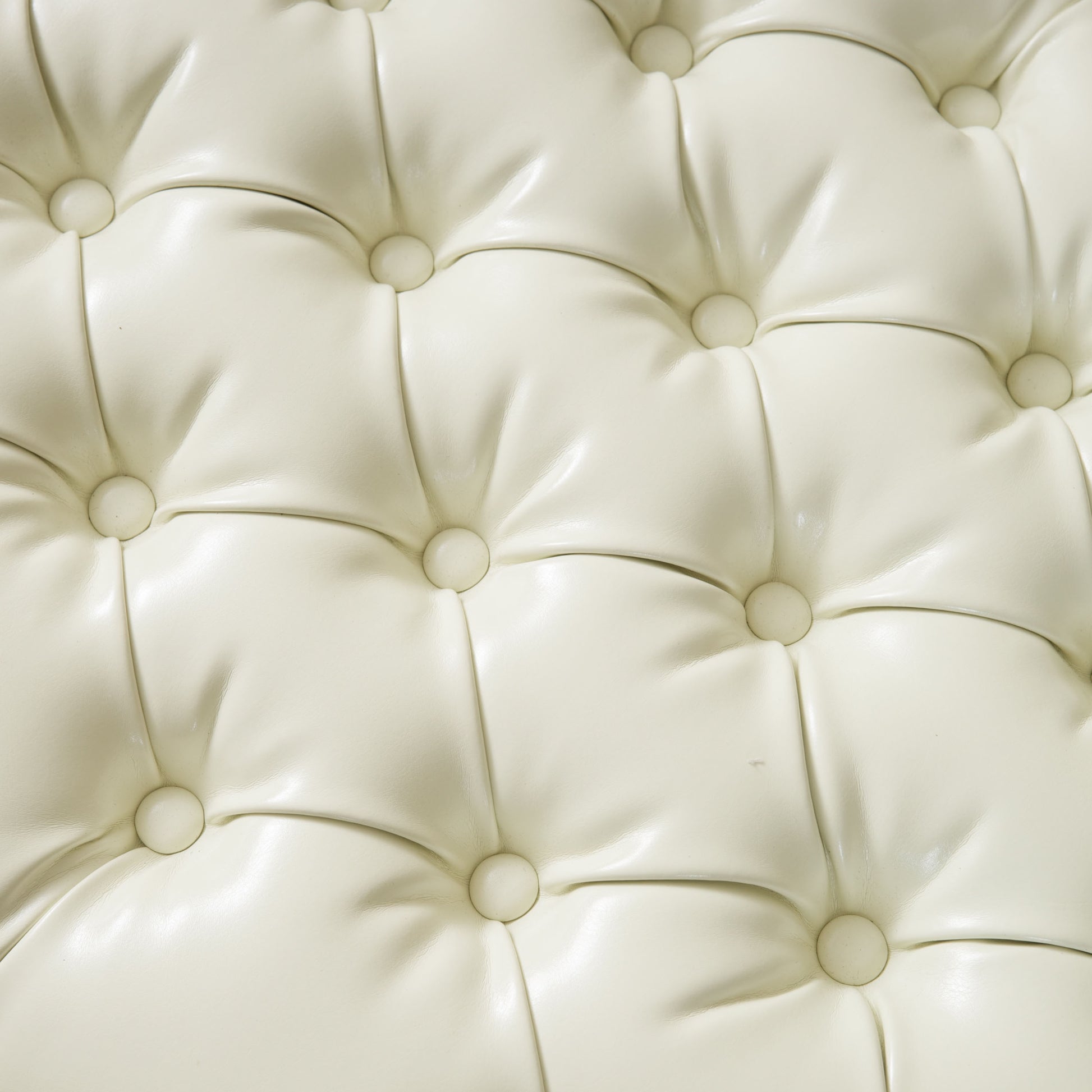 Cream tufted faux leather ottoman detail