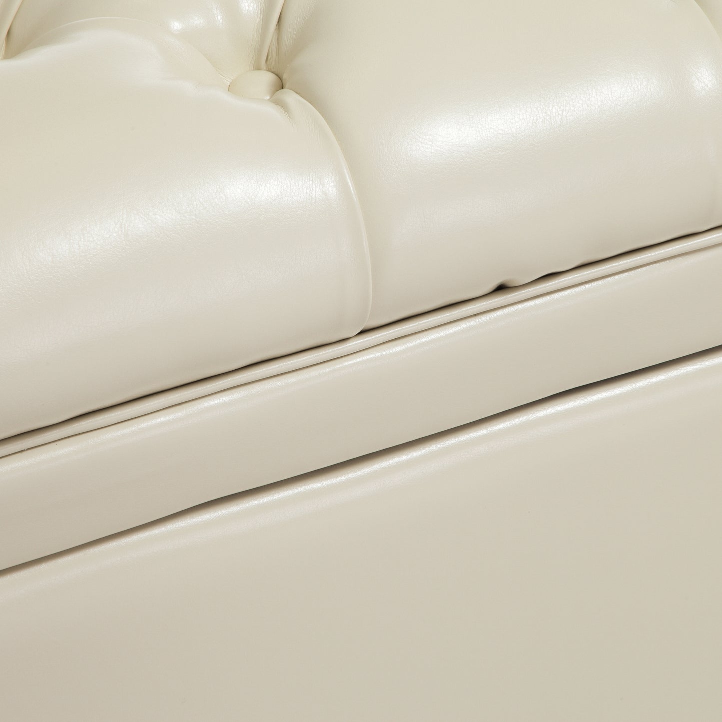 Closeup of tufted ivory faux leather upholstery