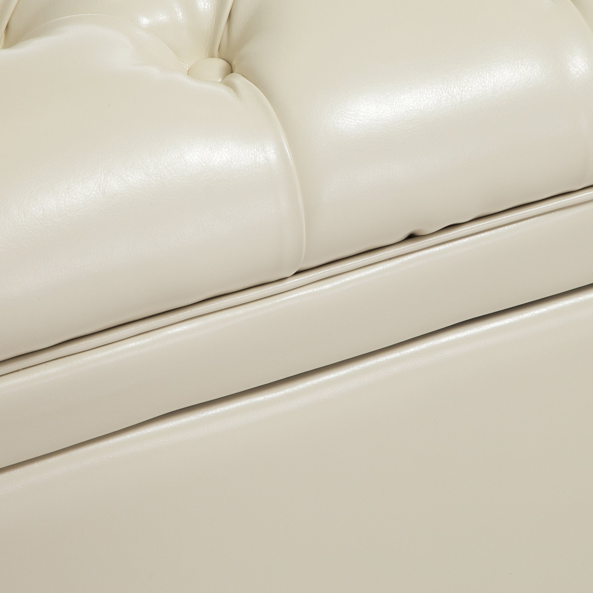 Closeup of tufted ivory faux leather upholstery