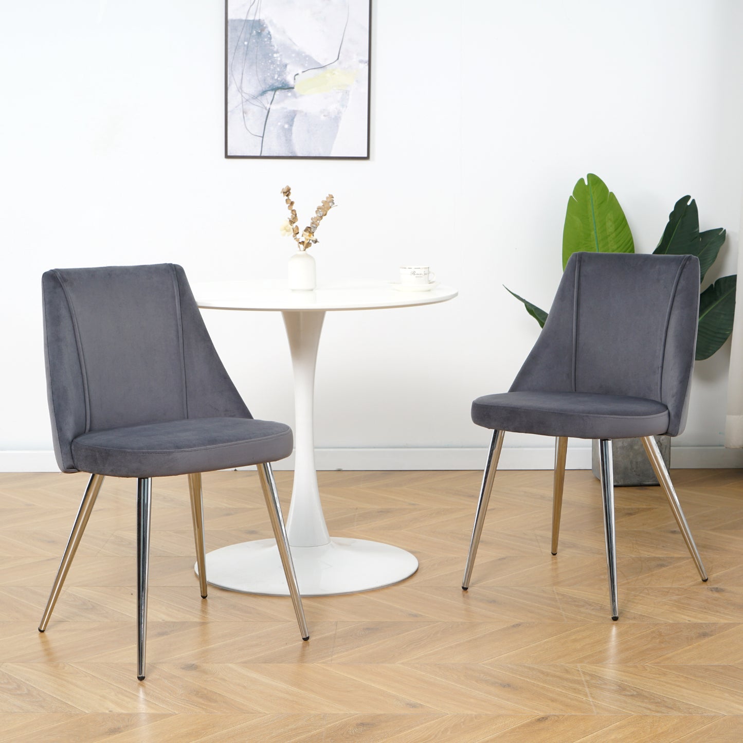 Two dark grey velvet dining chairs with chrome legs