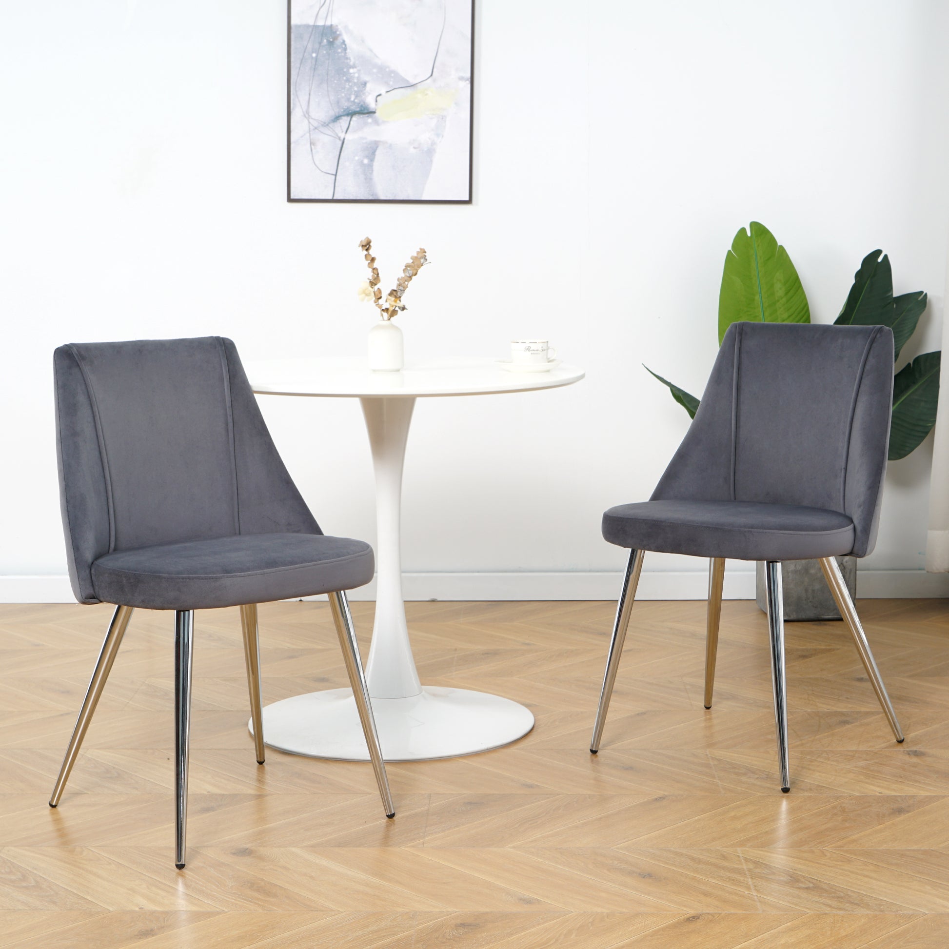 Two dark grey velvet dining chairs with chrome legs
