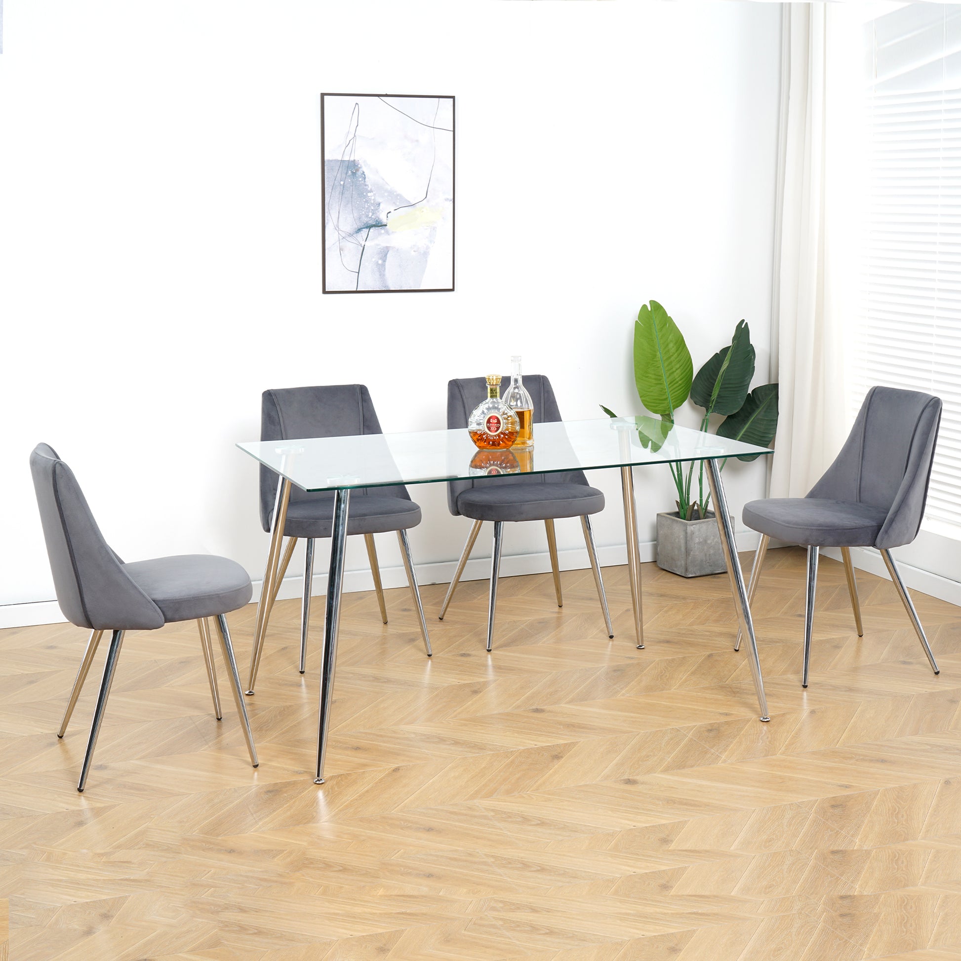 Glass dining table with four grey velvet chairs and chrome legs