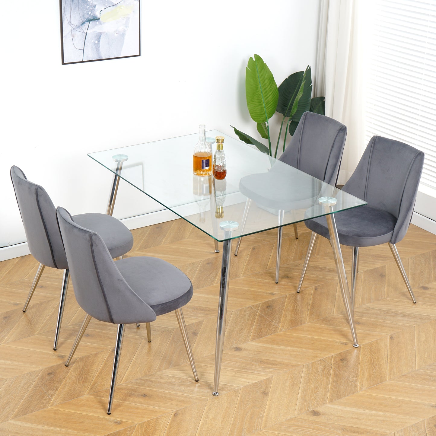 Modern glass dining table with four grey velvet chairs and chrome legs