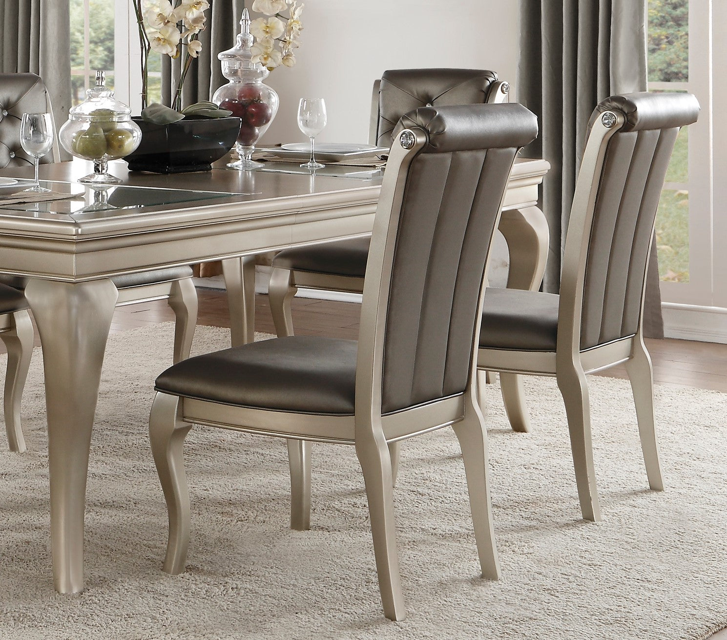 Elegant dining chairs with tufted taupe upholstery and ornate silver frames perfect for a formal dining room