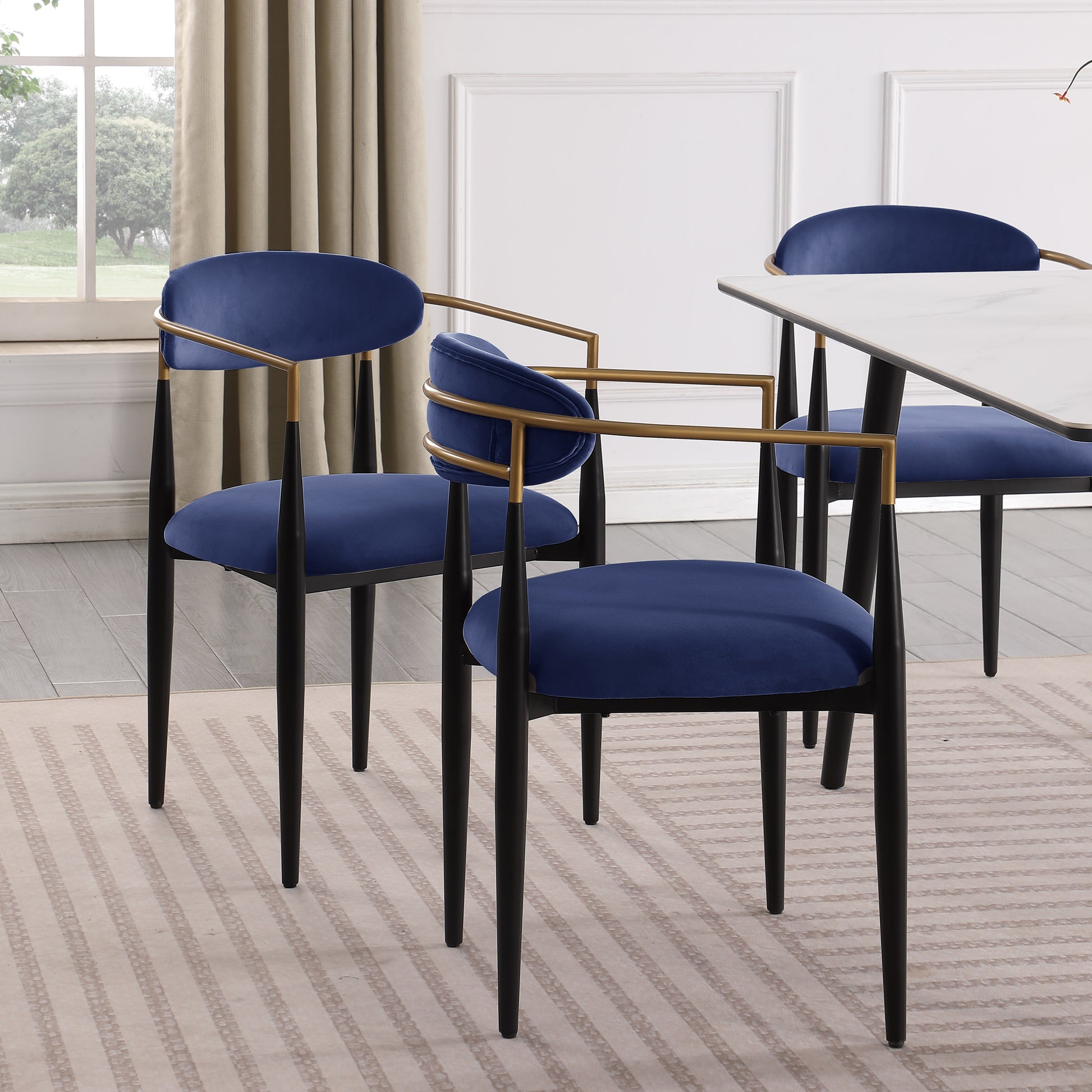 Navy velvet dining chair with gold metal arms and black legs