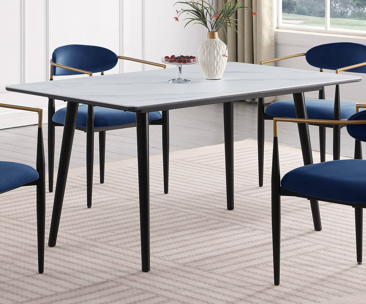 Rectangular white marble dining table with black legs and blue velvet chairs