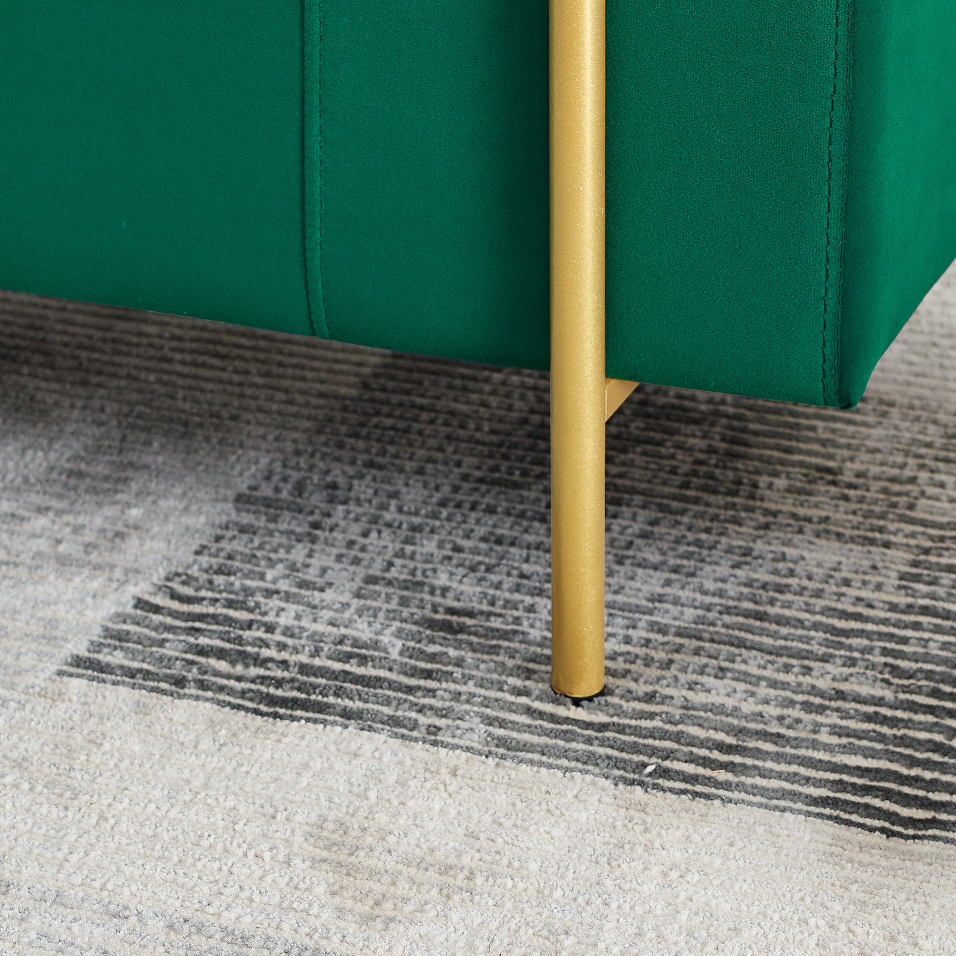 Emerald green velvet couch detail with gold tapered leg