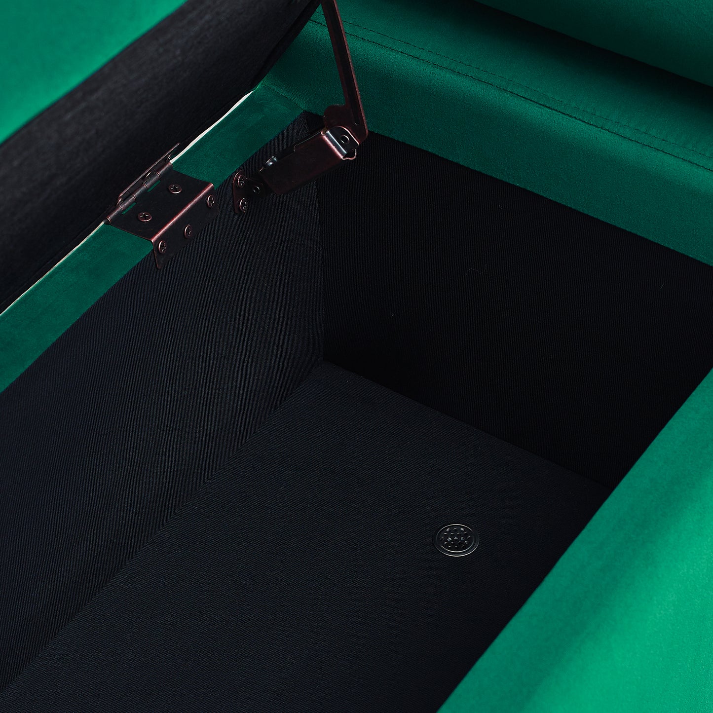 Emerald green velvet ottoman with hinged lid open revealing black interior