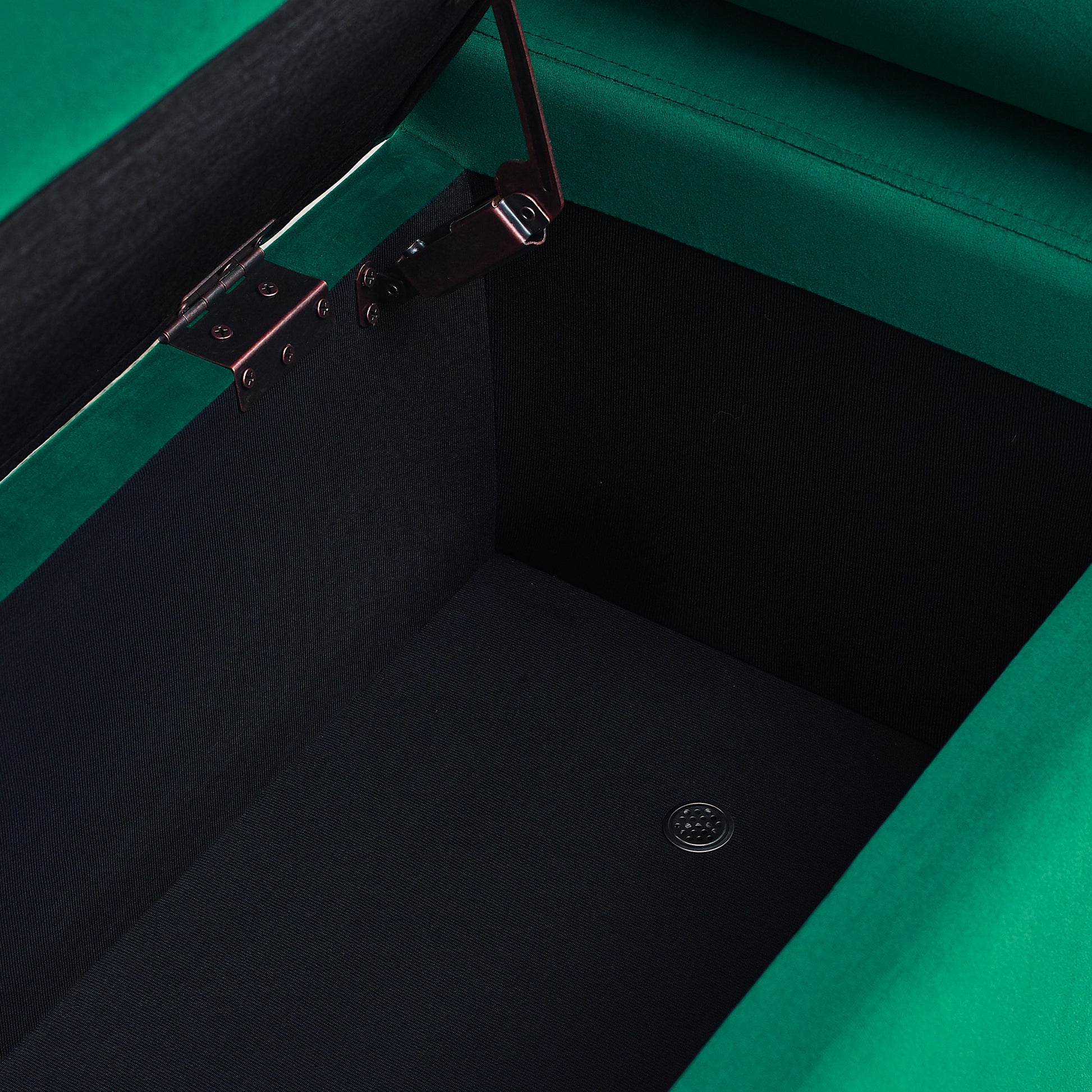 Emerald green velvet ottoman with hinged lid open revealing black interior