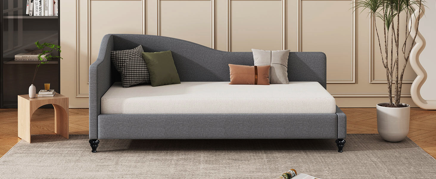 Dark grey fabric daybed with curved back and scatter cushions