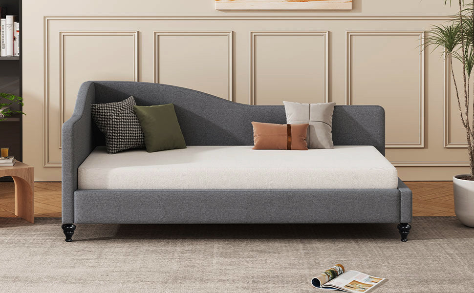 Elegant grey fabric daybed with curved backrest and decorative pillows
