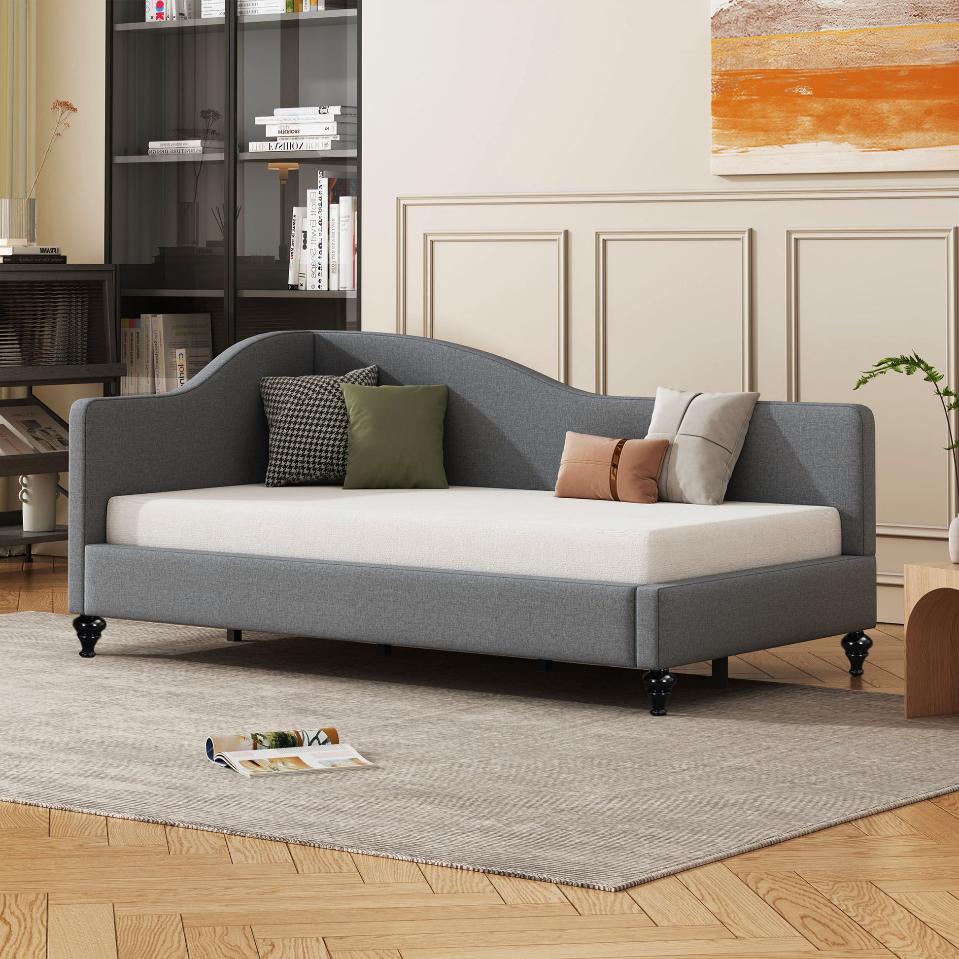 Gray fabric daybed with curved backrest and plush throw pillows