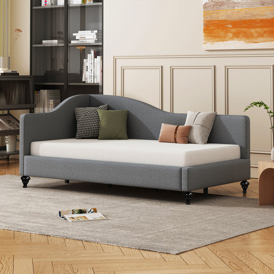 Gray fabric daybed with curved backrest and plush throw pillows