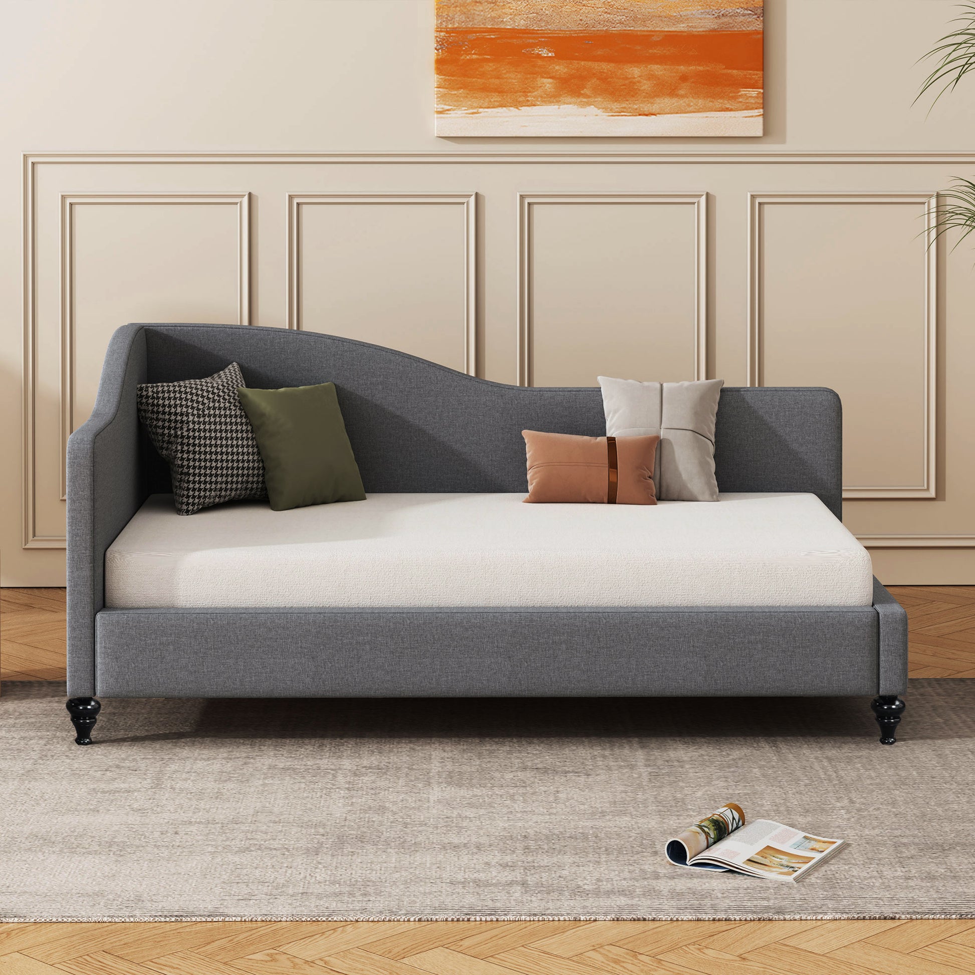 Gray fabric daybed with curved backrest and tufted mattress