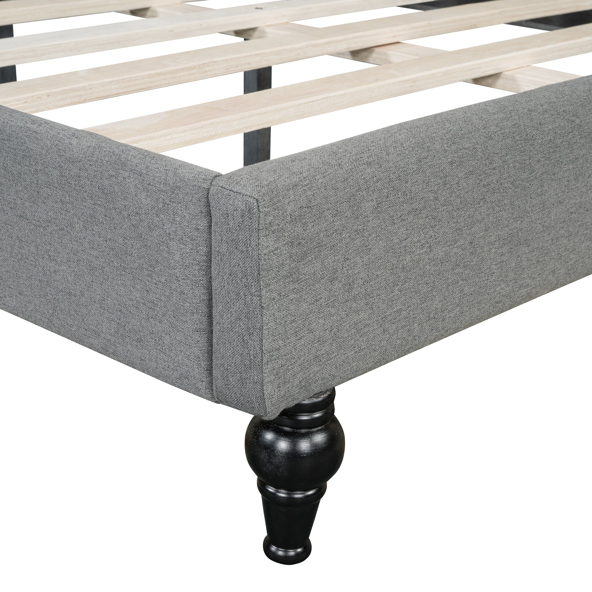 Gray upholstered bed frame with wooden slats and black turned legs
