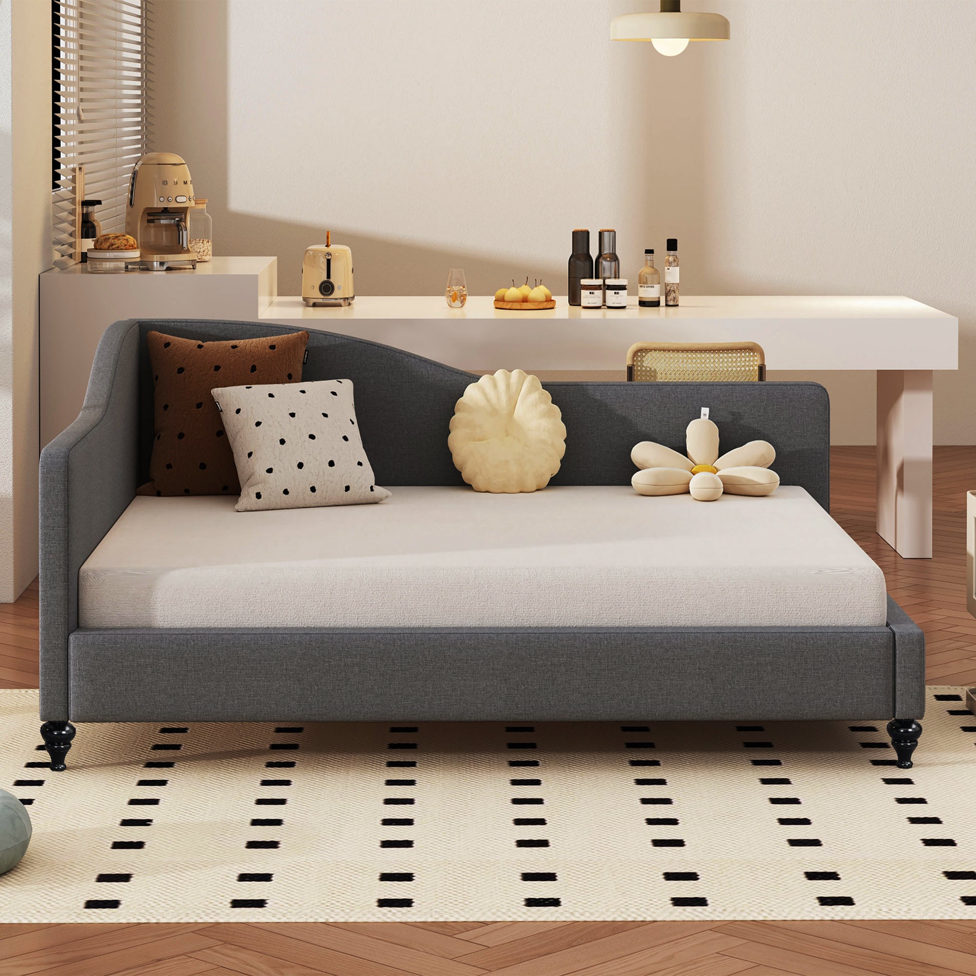 Dark grey fabric daybed with elegant curved back and beige mattress