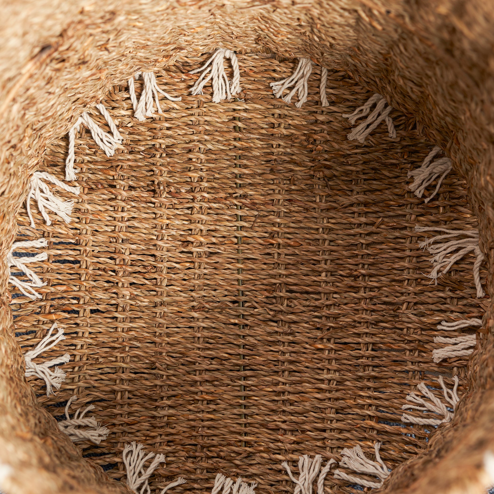 Woven natural fiber storage basket with decorative tassels