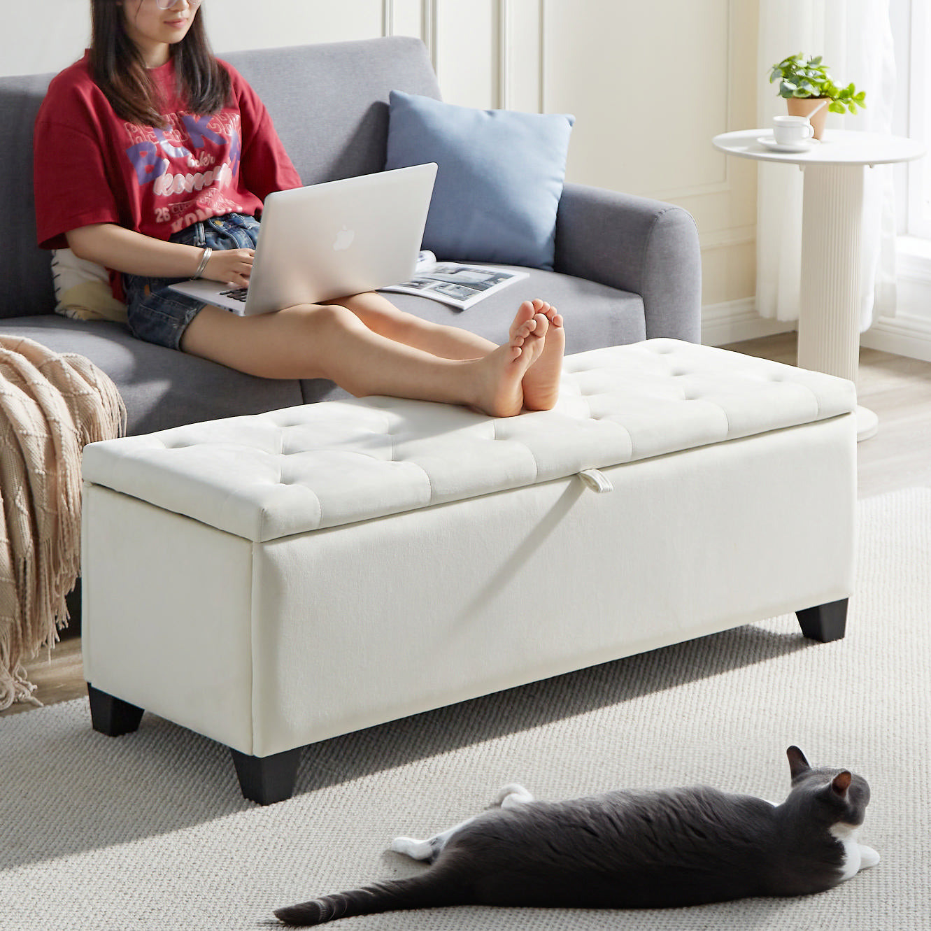Tufted white storage ottoman with dark wooden legs and subtle linen texture