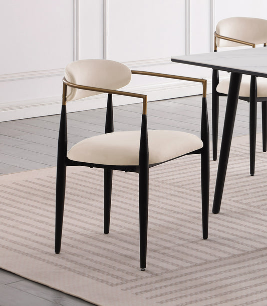 Cream upholstered dining chair with black tapered legs and gold arms