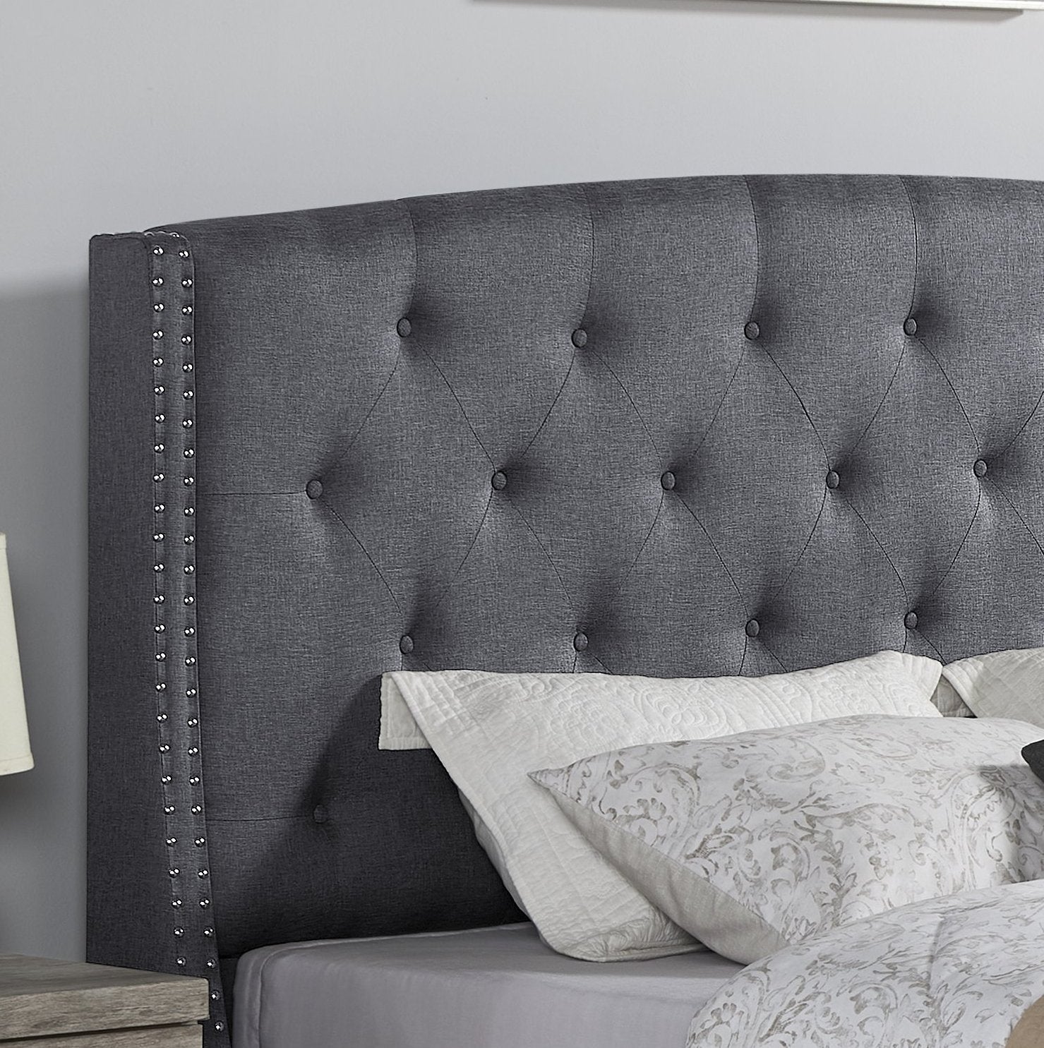 Dark gray upholstered headboard with diamond tufting and silver nailhead trim