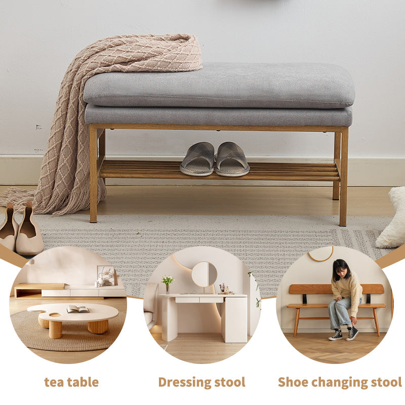 Gray upholstered bench with wooden shoe rack and beige throw