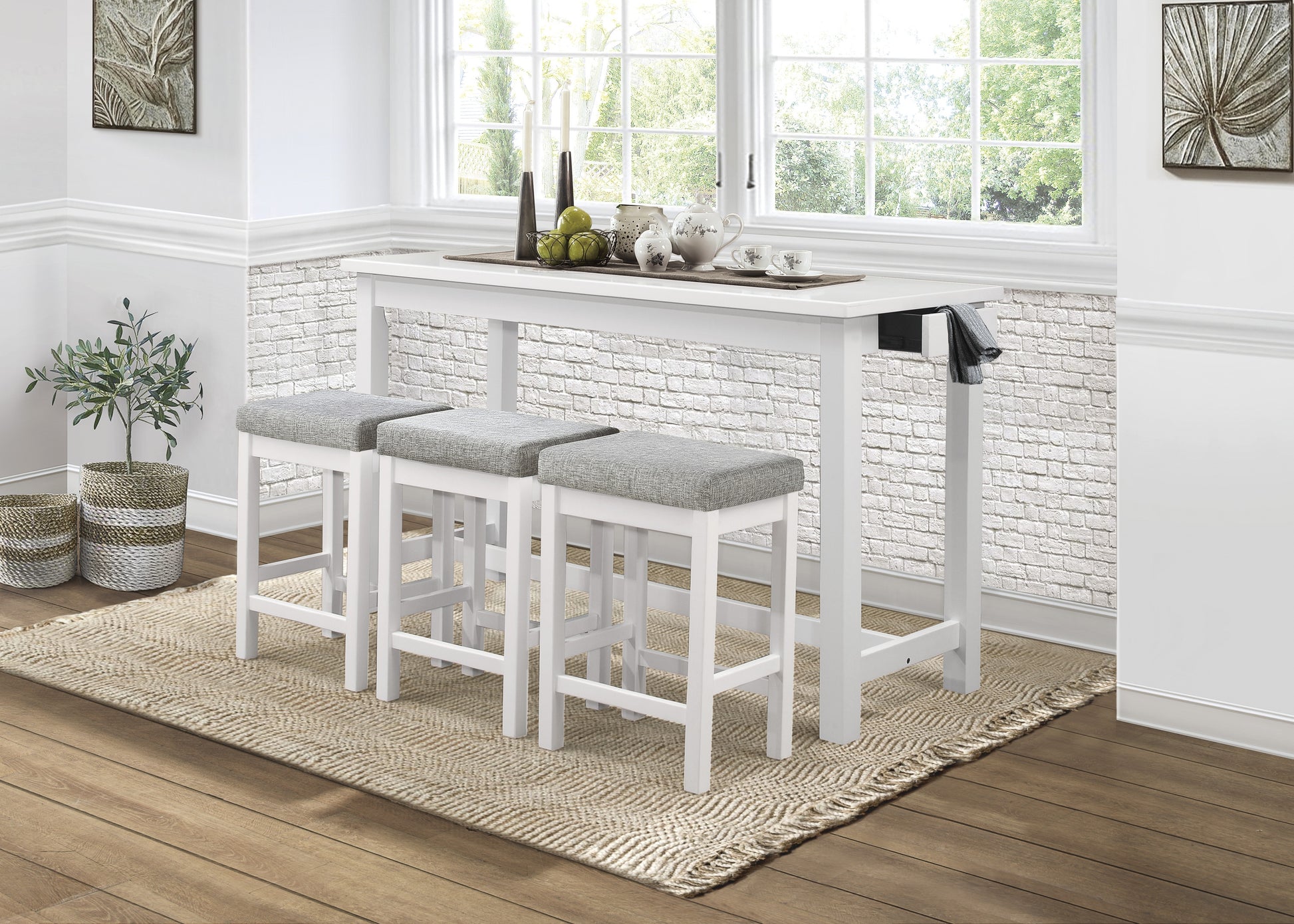 White bar table with three grey upholstered stools and a woven rug